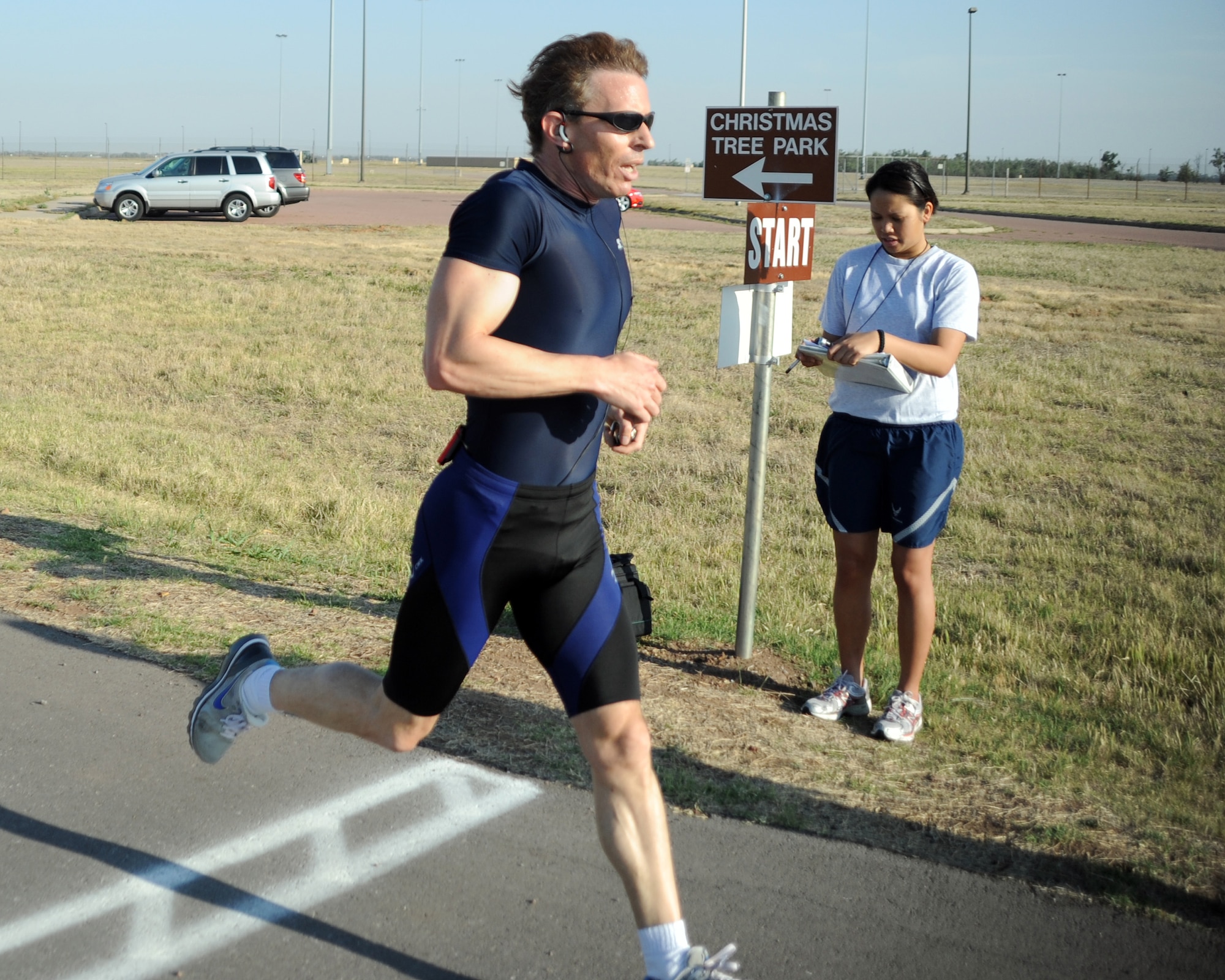 ALTUS AIR FORCE BASE, Okla. -- Mr. Eric Thayer, 97th Force Support Squadron section chief of the Airman and Family Readiness Center, runs across the finish line completing a physical fitness test May 9. Mr. Thayer has achieved perfect scores on his Air Force PT tests for seven consecutive years. To achieve a perfect score Mr. Thayer had to do at least 44 push-ups in one minute, 50 sit-ups in one minute, complete a 1.5-mile run in less than 9 minutes 45 seconds and have a waist measurement less than or equal to 32.5 inches. (U.S. Air Force photo by Airman 1st Class Kenneth W. Norman/ 97th Air Mobility Wing Public Affairs)