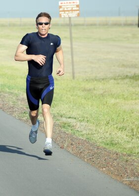 ALTUS AIR FORCE BASE, Okla. -- Mr. Eric Thayer, 97th Force Support Squadron section chief of the Airman and Family Readiness Center, sprints toward the finish line during a physical fitness test May 9. Mr. Thayer has achieved perfect scores on his Air Force PT tests for seven consecutive years. To achieve a perfect score Mr. Thayer had to do at least 44 push-ups in one minute, 50 sit-ups in one minute, complete a 1.5-mile run in less than 9 minutes 45 seconds and have a waist measurement less than or equal to 32.5 inches. (U.S. Air Force photo by Airman 1st Class Kenneth W. Norman/ 97th Air Mobility Wing Public Affairs)