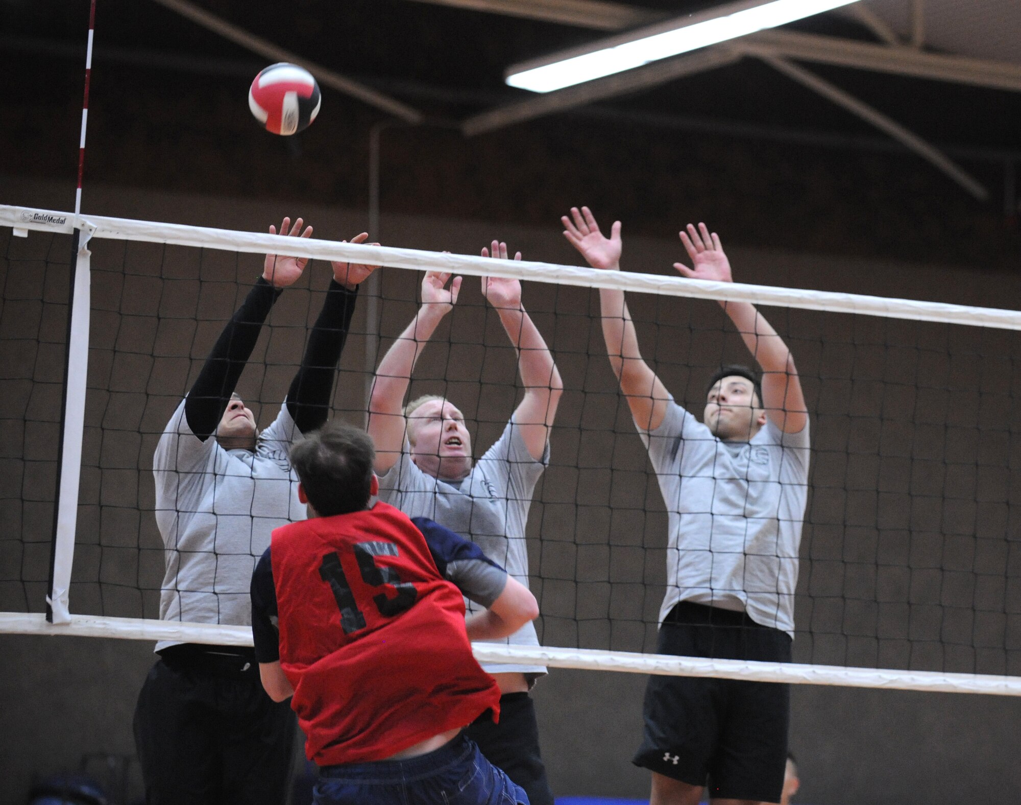 SPANGDAHLEM AIR BASE, Germany – Allen Pratt, 52nd Medical Group, spikes the ball as 52nd Civil Engineer Squadron defenders attempt to block the shot during the intramural volleyball championship series here May 9. The CES defeated MDG 25-16, 19-25, 15-10 to become the intramural volleyball champions. (U.S. Air Force photo/Senior Airman Nathanael Callon)