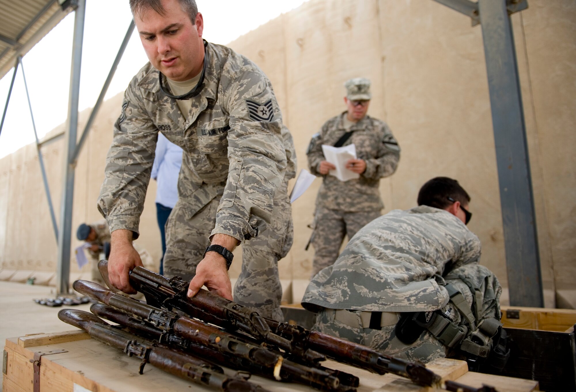 ALI AIR BASE, Iraq -- Tech. Sgt. Jason Ross, 321st Expeditionary Mission Support Advisory Group base transition team member, sets aside AK-47 assault rifles with verified serial numbers April 27. The weapons were delivered as part of the process for opening an Iraqi air force armory so the Iraqis can provide their own base security. Sergeant Ross is deployed from Aviano Air Base, Italy, and is a native of Iola, Kan. (U.S. Air Force photo by Staff Sgt. Levi Riendeau)