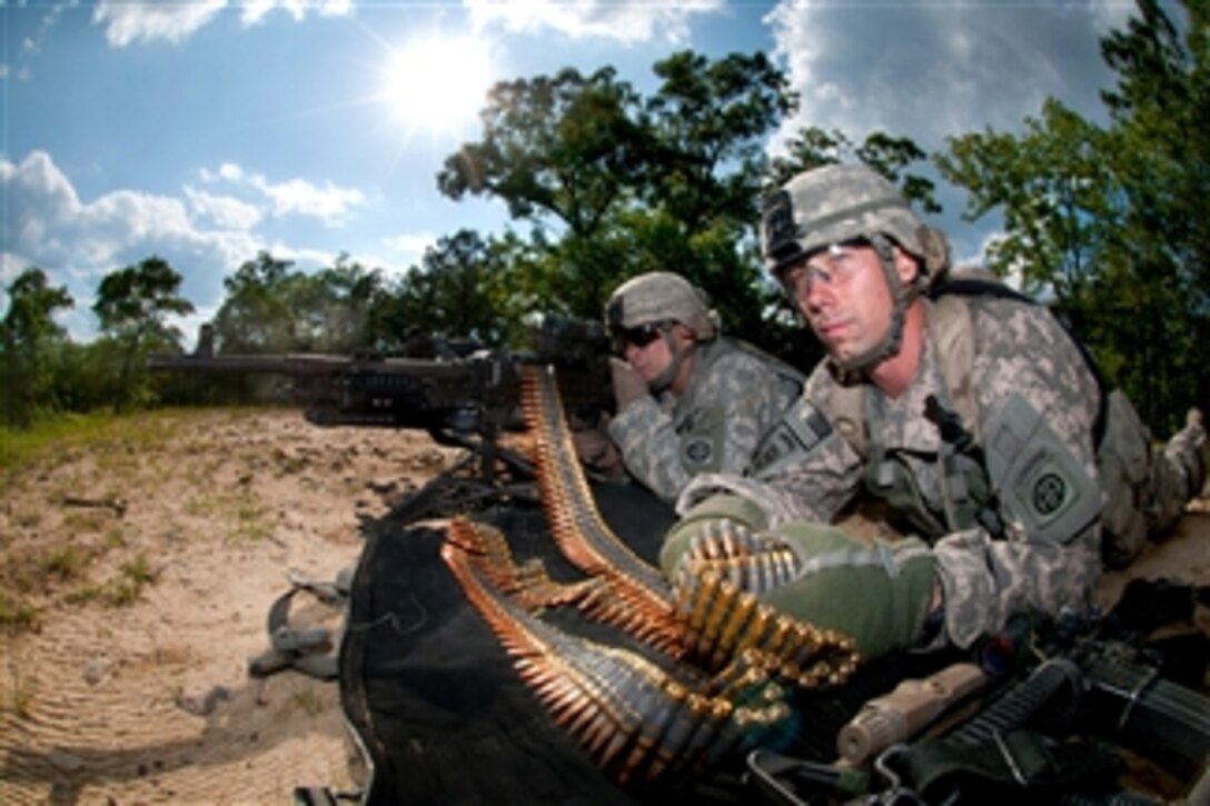 Army Spc. Robert Woodworth feeds ammunition to Spc. John Thrasher's M240-B machine gun while providing covering fire in an assault on an enemy position during a training exercise at Fort Bragg, N.C., on May 4, 2011.  