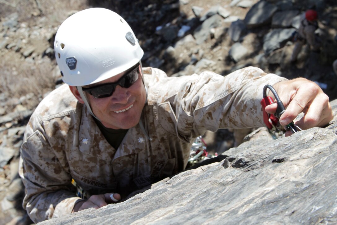 Lieutenant Col. Keith Rivinius, a student in the Instructor Qualification Course, places a climbing hook into a crack in the rock to gain a good support for his ropes May 11, 2011, in a training area of Marine Corps Mountain Warfare Training Center Bridgeport during the course.