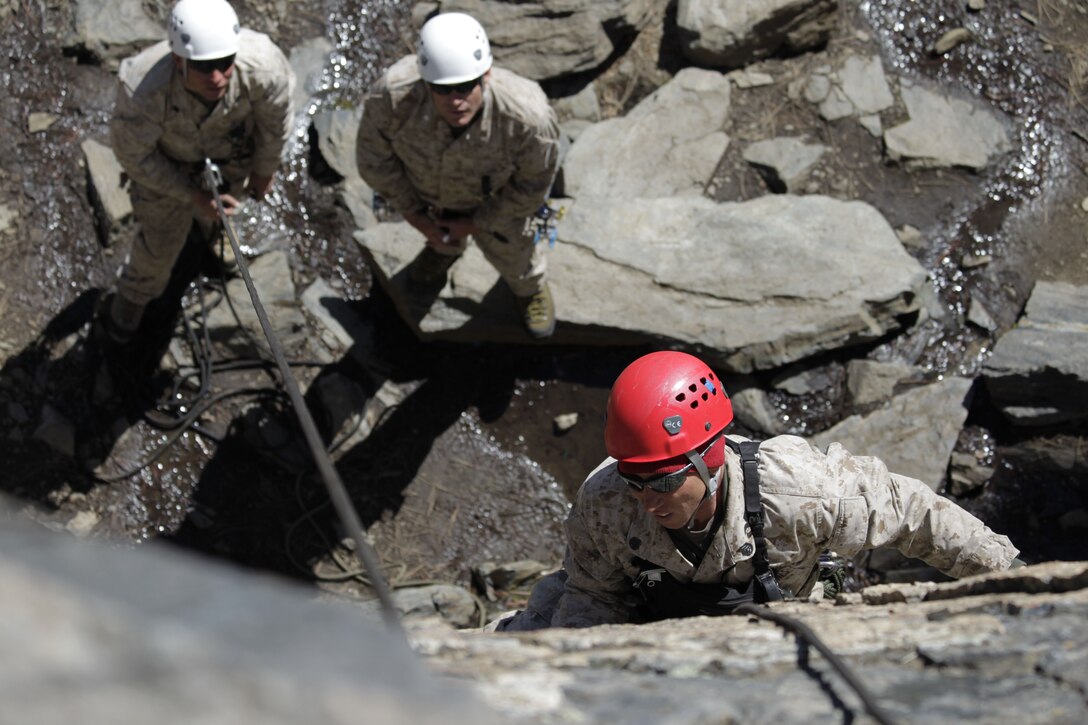 An instructor with the Instructor Qualification Course, shows students the proper method of placing anchoring hooks before scaling a rock face May 11, 2011.