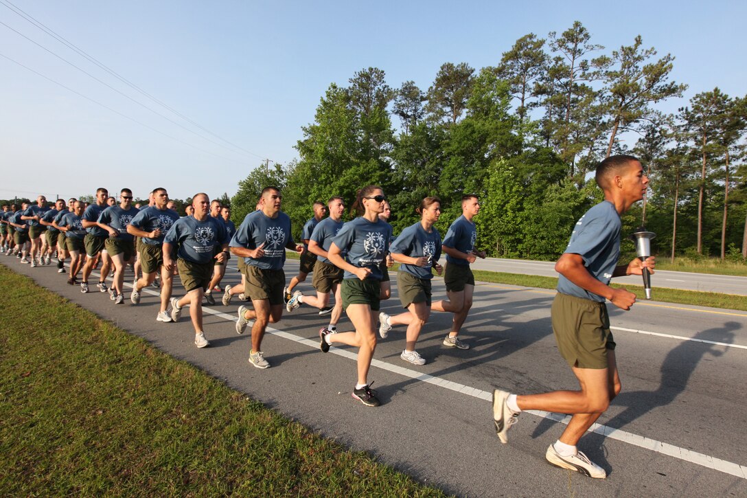 More than 30 Marines, Sailors and civilians from Cherry Point run down U.S. Highway 70 on their way to New Bern carrying the torch that will start the Craven County Spring Games Competition for the Special Olympics at Grover C. Fields Middle School May 12. More than 250 athletes between the ages of 5 and 65 competed in the track and field style events, which Cherry Point volunteers helped coordinate. The group of volunteers started the more than 15-mile run, which began at Wal-Mart in Havelock with a one-mile formation run and continued by passing the torch off while teams of three ran in one-mile legs. The volunteers ran the final mile in the formation, which took them into the field where the athletes awaited them.
