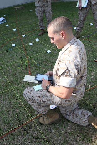 2nd Lt. Brian C. Neri studies proper procedures prior to finalizing an airstrike against enemy troops in the open, two grid squares in front of his position. Neri and a group of fellow 2nd lieutenants were practicing calling in airstrikes behind the headquarters building aboard Marine Corps Air Station Cherry Point May 12 prior to being deployed to combat units in Afghanistan as individual augments.