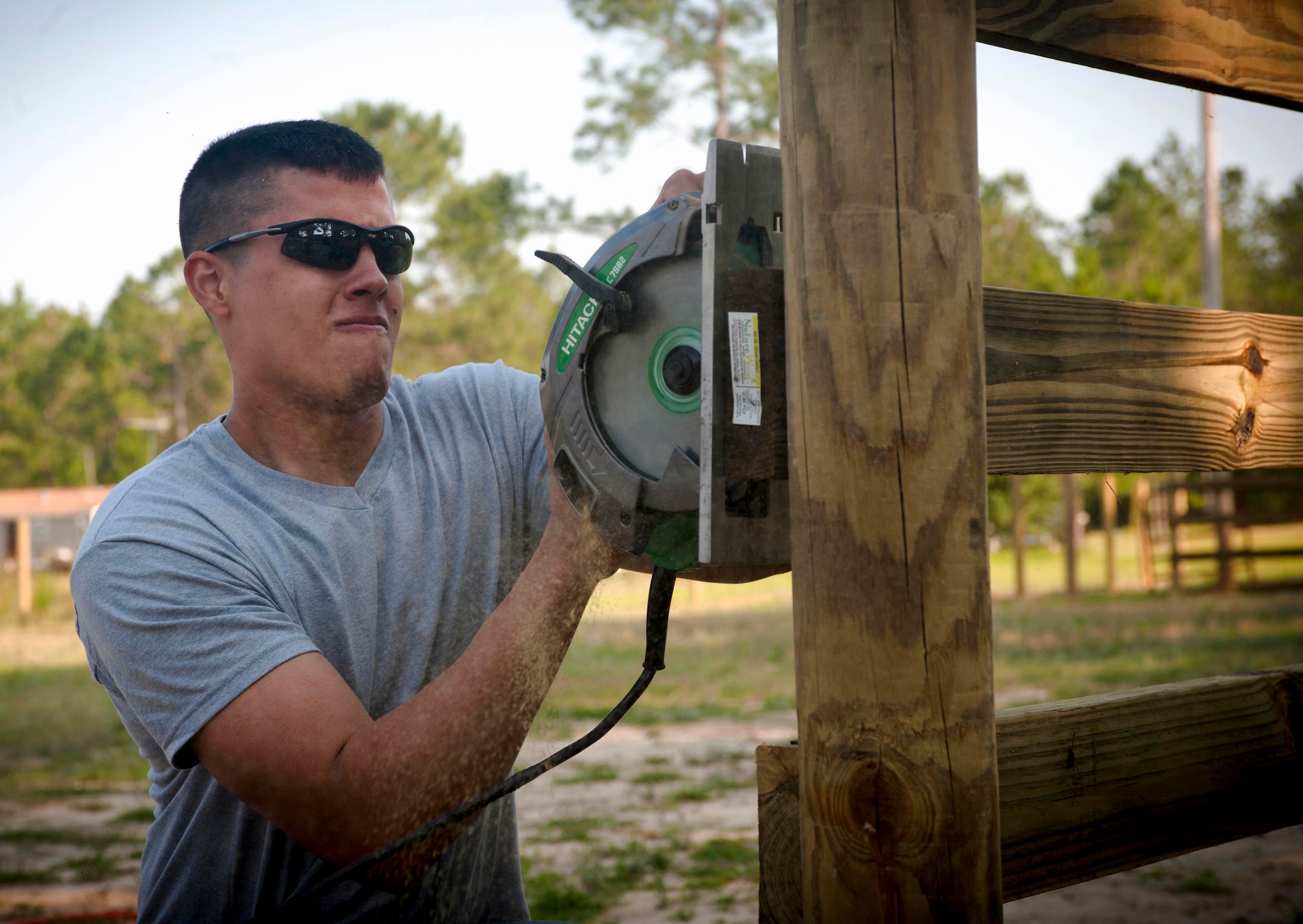 QUITMAN, Ga. -- Senior Airman Josiah Tirado-Bailey, 23rd Fighter Group intelligence, saws through a board to even the edges of a fence May 11 at the Hopes and Dreams Riding Facility. The facility offers many outdoor activities to help relieve stress and symptoms of post-traumatic stress disorder in service members. (U.S. Air Force photo/Airman 1st Class Jarrod Grammel)(RELEASED)