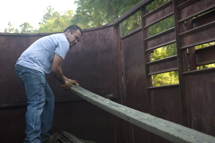 QUITMAN, Ga. -- Senior Airman Jun Salatandre, 41st Helicopter Maintenance Unit HH-60 crew chief, loads boards into the back of a truck May 11 at the Hopes and Dreams Riding Facility. More than a dozen Airmen volunteered in a project that would benefit veterans with post-traumatic stress disorder. (U.S. Air Force photo/Airman 1st Class Jarrod Grammel)