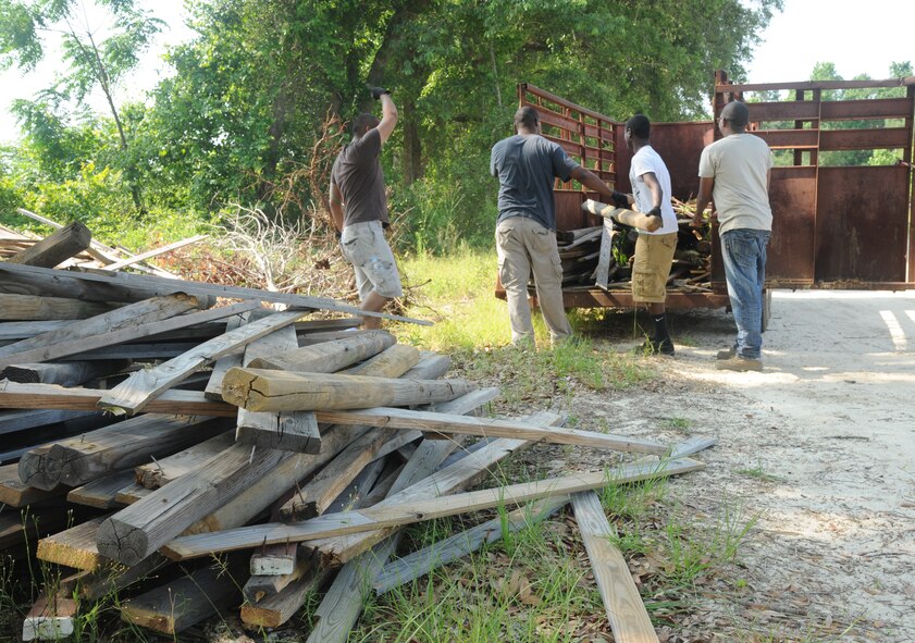 QUITMAN, Ga. -- Members of the 41st Helicopter Maintenance Unit help unload piles of wood May 11. More than a dozen Airmen from Moody Air Force Base, Ga., volunteered to help build a new arena at a riding facility which uses unique therapy to help improve the lives of those affected by post-traumatic stress disorder. (U.S. Air Force photo/Airman 1st Class Paul Francis)
