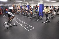 Texas Air Force Cycling Team captain Larry Gallo leads 19 participants through day one of an eight-week spin program May 9 at the Warhawk Fitness Center. The first class introduced participants to different riding positions and muscle fatigue, while they work up to the ultimate test during the final class: a 40-minute, max-effort time trial. (U.S. Air Force photo/Robbin Cresswell)