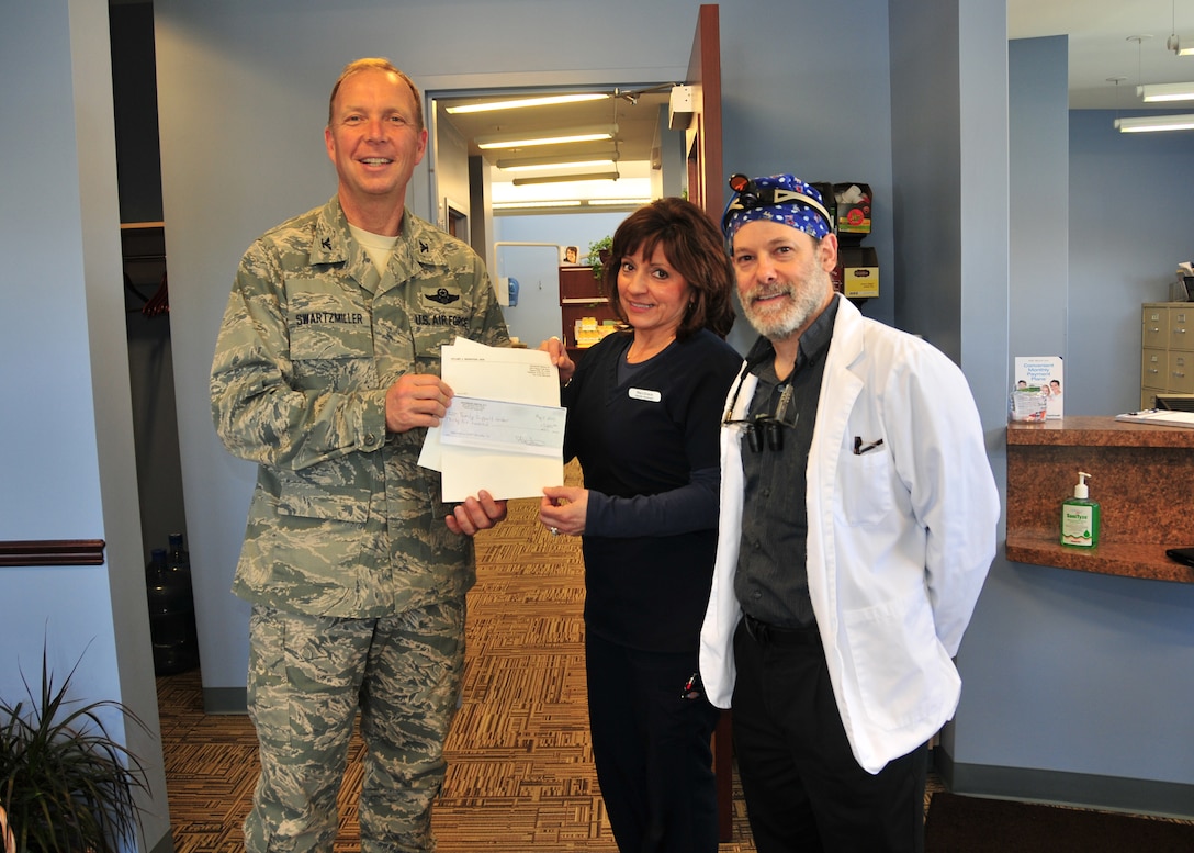 914th Airlift Wing Commander Col. Allan L. Swartzmiller receives a donation from Dental Assistant Mary Grace and Dr. Stuart Weinstein D.D.S. as part of Operation Whiter-Brighter, May 11, 2011, Niagara Falls, NY. Operation Whiter-Brighter has donated the proceeds from their tooth whitening service at their office to the Family Support Programs at the Niagara Falls Air Reserve Station. (U.S. Air Force photo by Staff Sgt. Joseph McKee)