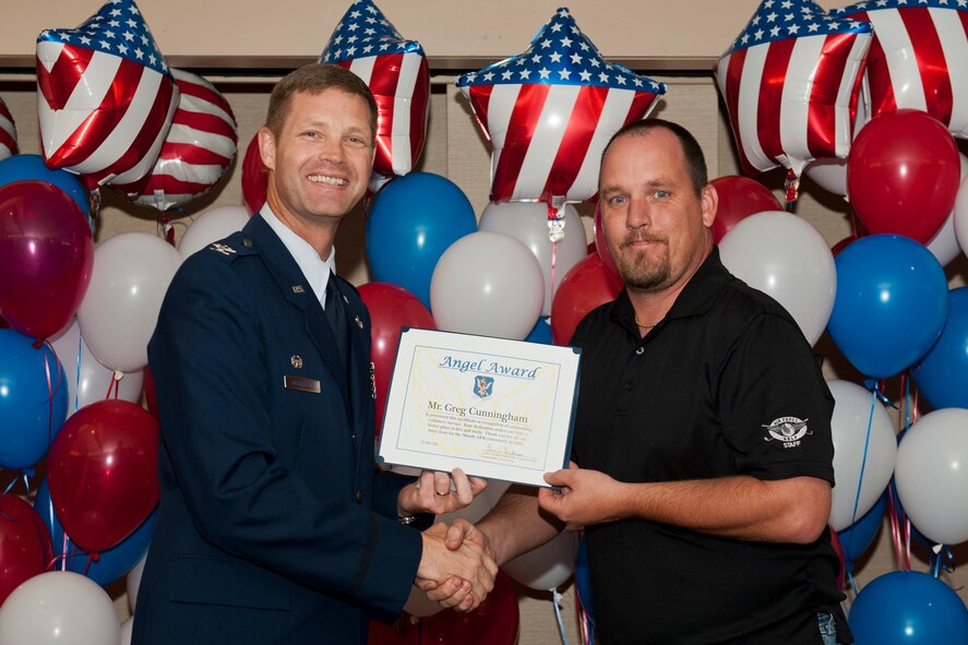 Greg Cunningham, Quiet Pines Golf Course employee, receives an Angel Award certificate from Col. Gary Henderson, 23rd Wing commander, May 12 during the 2011 Annual Volunteer Recognition Ceremony at Moody Air Force Base, Ga. The Angel Award recognizes volunteers who significantly enrich the quality of life on military installations. Mr. Cunningham’s volunteer work includes assembling more than 300 prize packs during Rabies Awareness Day, directing more than 20 volunteers in support of Tops in Blue and assisting with set up and decorations during the annual Christmas Tree Lighting ceremony. (U.S. Air Force photo/Staff Sgt. Jamal D. Sutter)(RELEASED)