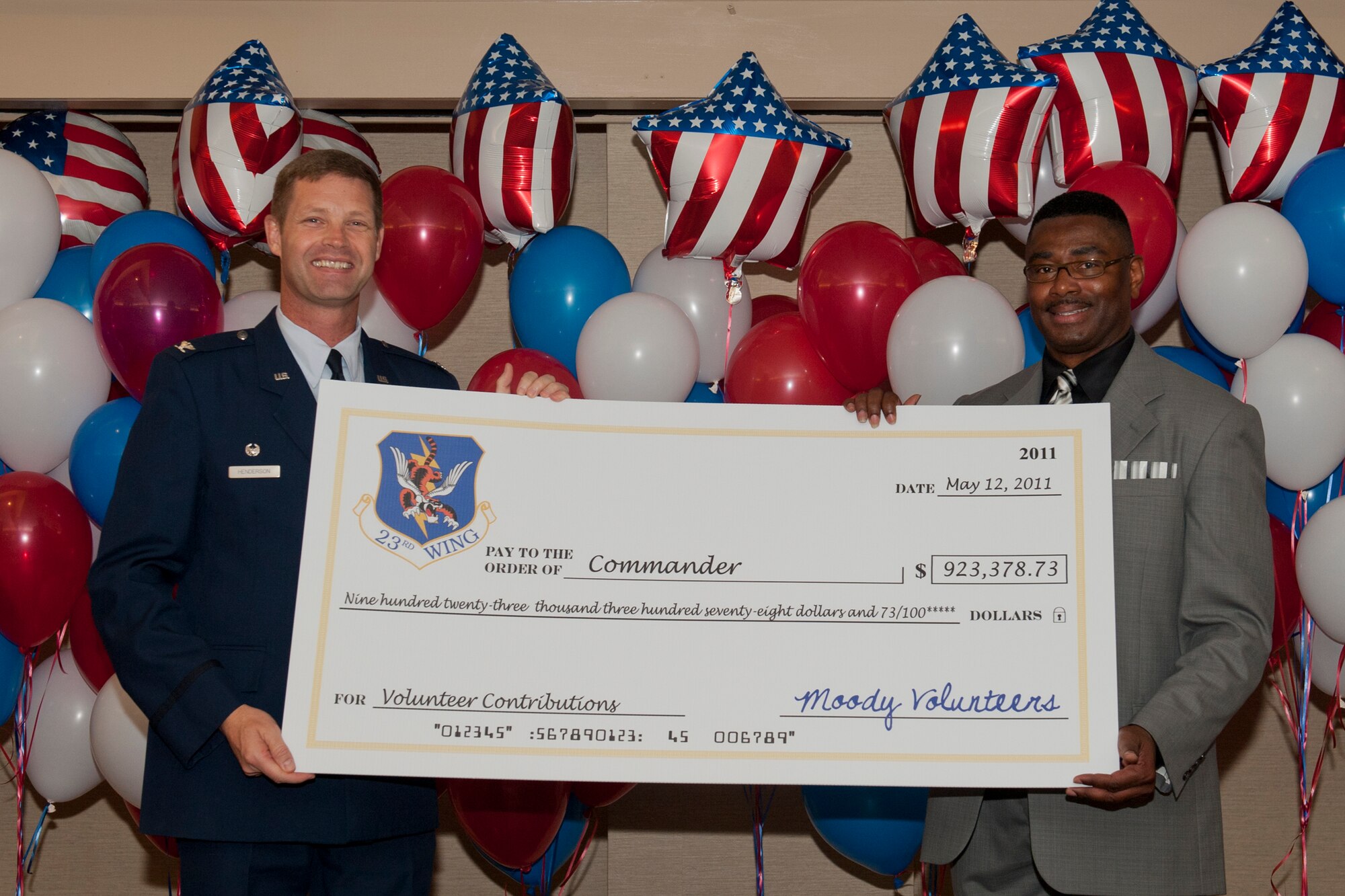 On behalf of the 23rd Wing, Col. Gary Henderson, 23rd WG commander, receives a symbolic check worth $923,378 from Victor Johnson, 23rd Force Support Squadron community readiness consultant, May 12 during the 2011 Annual Volunteer Recognition Ceremony at Moody Air Force Base, Ga. Last year, more than 1,500 Moody members donated more than 40,000 hours of volunteer service to the community. The check amount represented the equivalent of what the services would have cost if the volunteers were a paid staff. (U.S. Air Force photo/Staff Sgt. Jamal D. Sutter)(RELEASED)