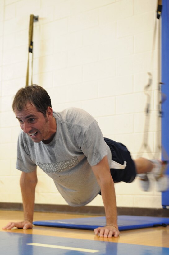 Jim Taccogno, spouse of 1st Lt Sharee Taccogno, 633d Medical Group inpatient clinical nurse, performs a TRX Suspension Training exercise in the Shellbank Fitness Center at Langley Air Force Base, Va., May 10, 2011. The demonstration was held as part of May Fitness Month which is held annually to promote fitness and healthier lifestyles. (U.S. Air Force photo by Airman 1st Class Kayla Newman/Released)