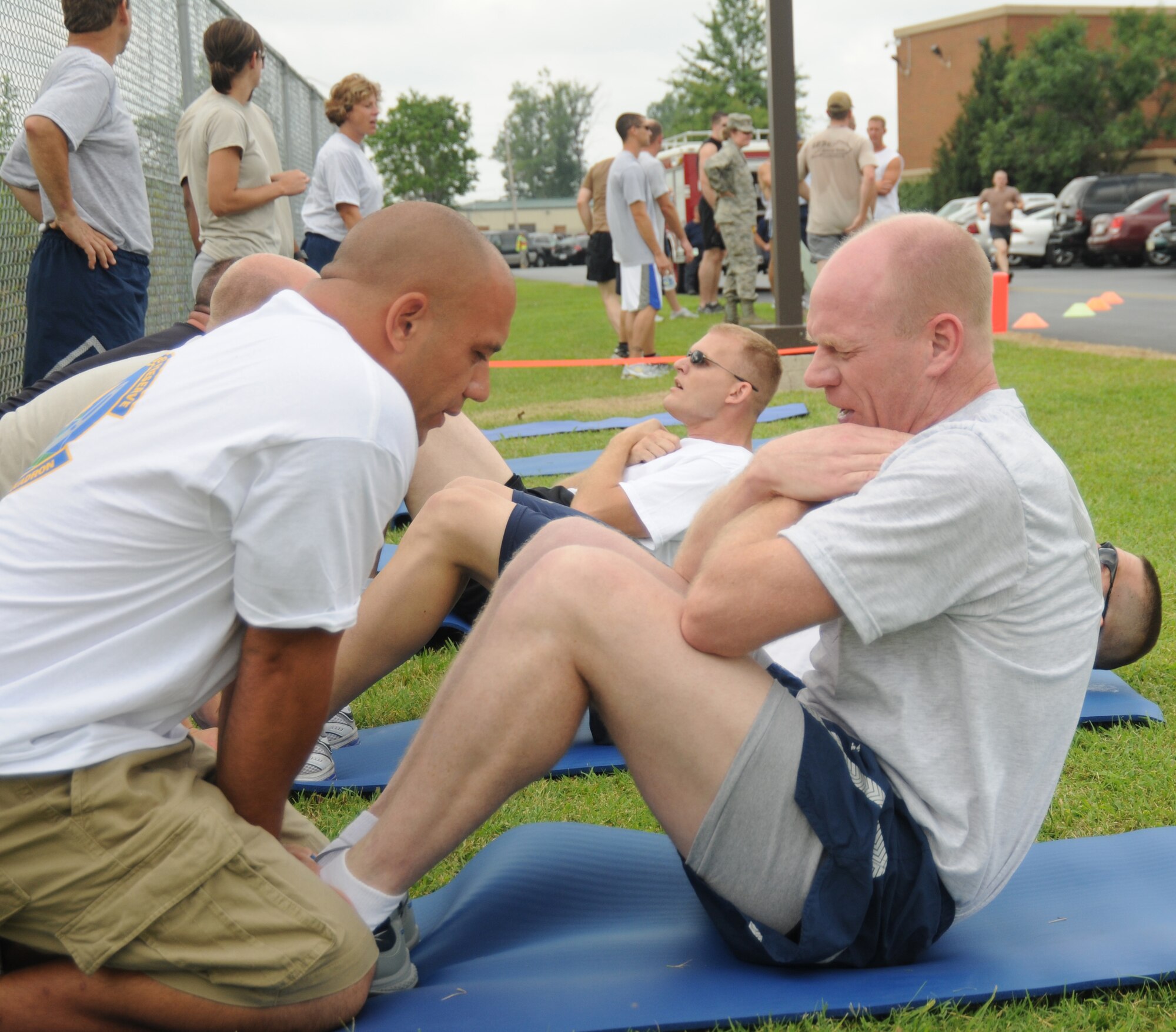 Master Sgt. Tim Kenney, Kentucky Air National Guard 123d Maintenance Squadron, holds the feet of Senior Master Sgt. Scott Andrews, 123d Logistics Readiness Squadron, as he performs crunches during the Wing Fitness Challenge July 17, 2010.  Military members of the KyANG engage in regular physical fitness training to meet or exceed the fitness standards set forth by the United States Air Force to ensure readiness to meet the demands of duty performance both at home station and in a deployed environment.  (U.S. Air Force photo by Tech. Sgt. Dennis Flora)