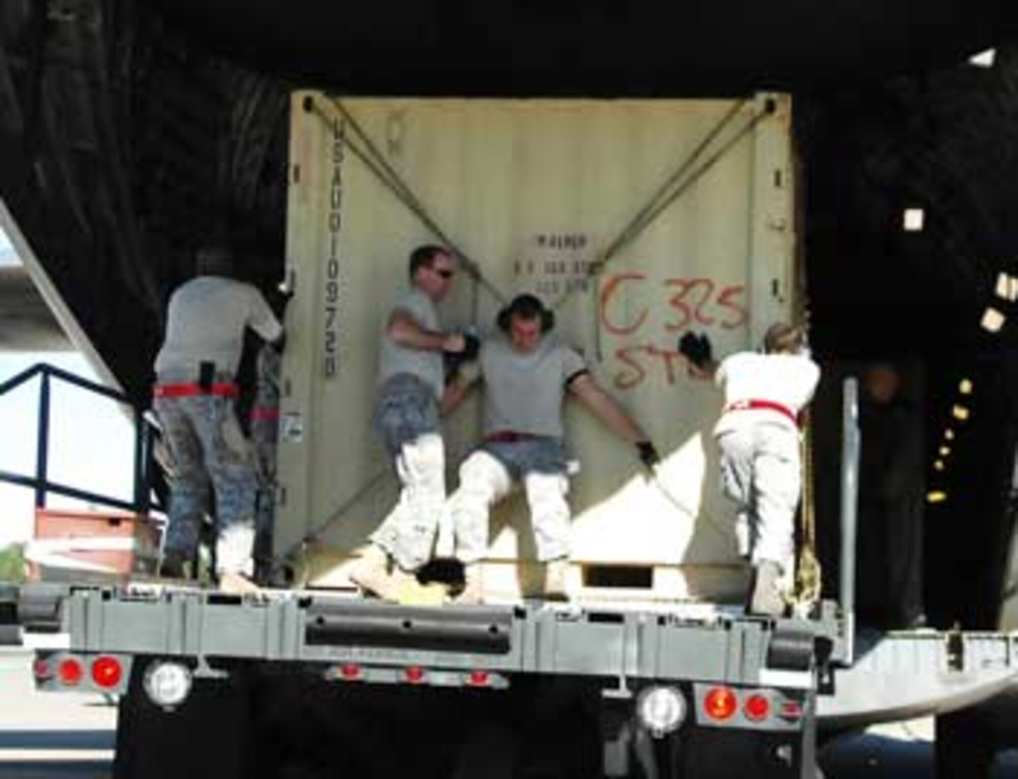 Tech. Sgt. Seth Abel, second from left, 3rd Aerial Port Squadron, helps his fellow “Port Dawgs” load mission essential cargo onto an aircraft headed downrange. Able inspected the cargo for anything that may damage the aircraft or cause injury to any of the crew.

