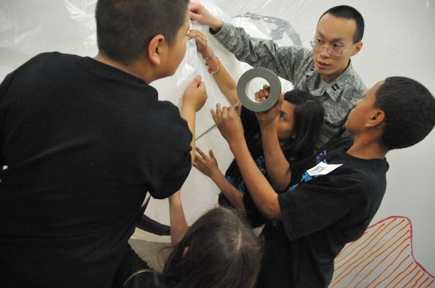 Capt. Alan Louie, AFOTEC, helps students from East San Jose Elementary of Albuquerque connect a tunnel from one habitat to another at the Convention Center on May 6. Schools from across New Mexico participated in the Mission to Mars program, where classrooms follow curriculum set by AFRL. As a final project, students build habitats that connect to other habitats and present information they have learned about outer space.