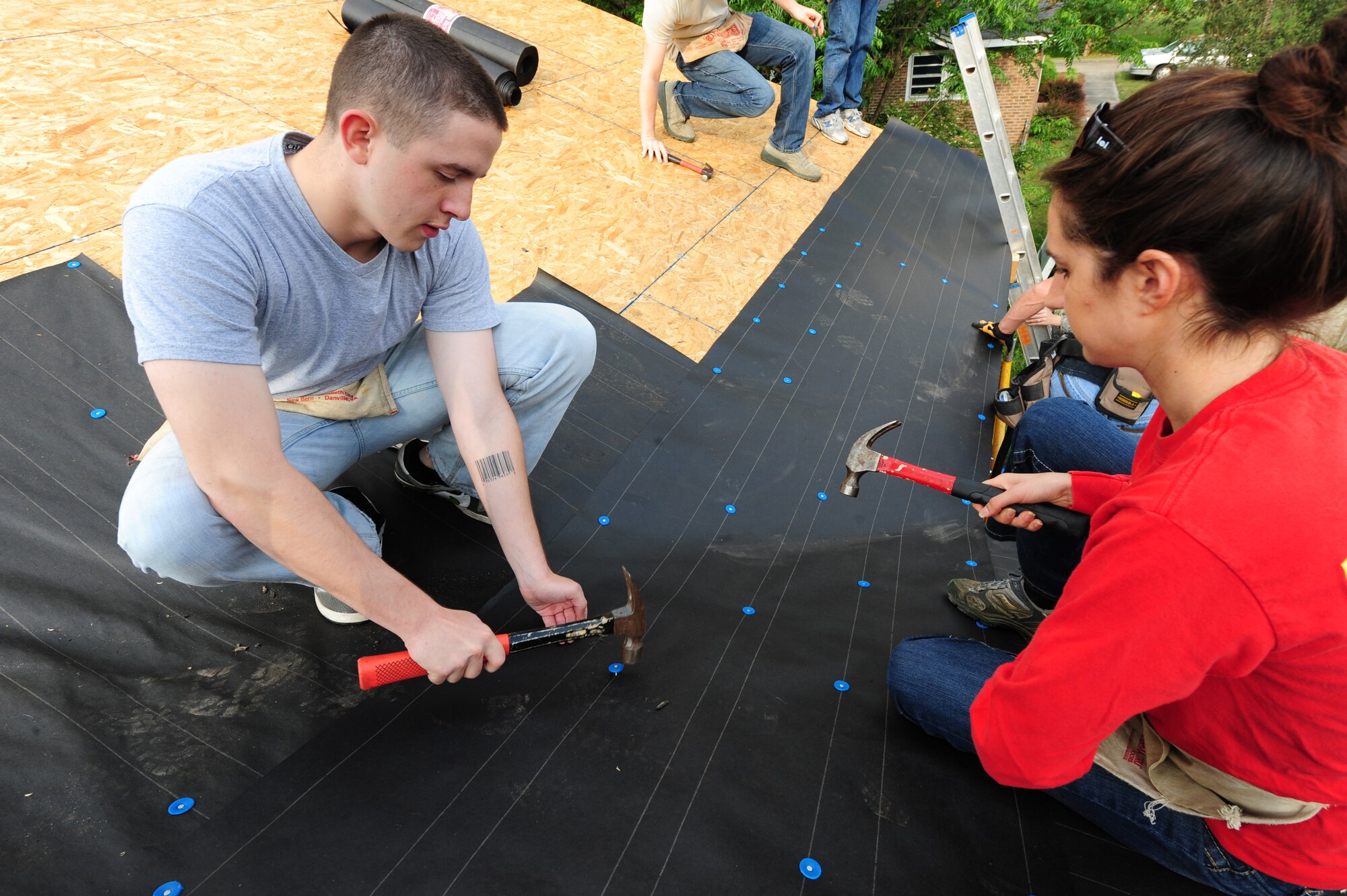SEYMOUR JOHNSON AIR FORCE BASE, N.C. -- Airman 1st Class Kyle Buettner and Valerie Keefer nail roofing paper on to a house being built by the Habitat for Humanity foundation with assistance from Airmen and dependents here, May 10, 2011. Volunteer days for Habitat for Humanity are Tuesdays, Thursdays and Saturdays. Airman Buettner, 4th Communications Squadron knowledge operations apprentice, hails from Sturbridge, Mass., and Mrs. Keefer, wife of Capt. Stephen Keefer, 336th Fighter Squadron, hails from Mechanicsburg, Pa. (U.S. Air Force photo/Senior Airman Rae Perry)(RELEASED)