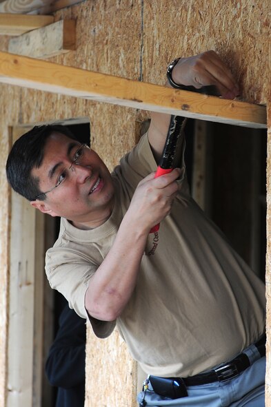 SEYMOUR JOHNSON AIR FORCE BASE, N.C. -- Chaplain (Maj.) Andrew Pak tacks down a particle board near a window opening on a Habitat for Humanity house in Goldsboro, May 10, 2011. Chaplain Pak gathered Airmen and dependents to help construct a house for Habitat for Humanity. Chaplain Pak, 4th Fighter Wing Chapel, hails from Glendale, Calif. (U.S. Air Force photo/Senior Airman Rae Perry)(RELEASED)