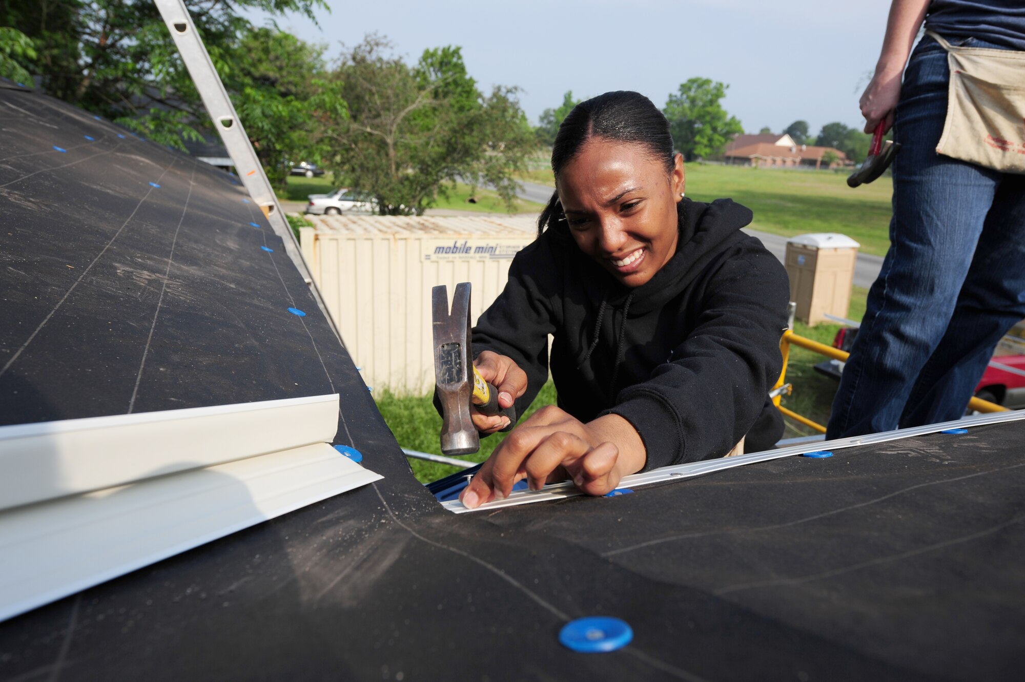 SEYMOUR JOHNSON AIR FORCE BASE, N.C. -- Staff Sgt. Candace King tacks down roof edging on a house being built by the Habitat for Humanity foundation with the assistance of Airmen and dependents here, May 10, 2011. The 4th Fighter Wing Chaplains office organized the event to assist Habitat for Humanity in building this house, which was behind schedule due to storms that hit most of eastern North Carolina in the past month. Sergeant King, 4th Equipment Maintenance Squadron munitions technical administrator, hails from New York. (U.S. Air Force photo/Senior Airman Rae Perry)(RELEASED)
