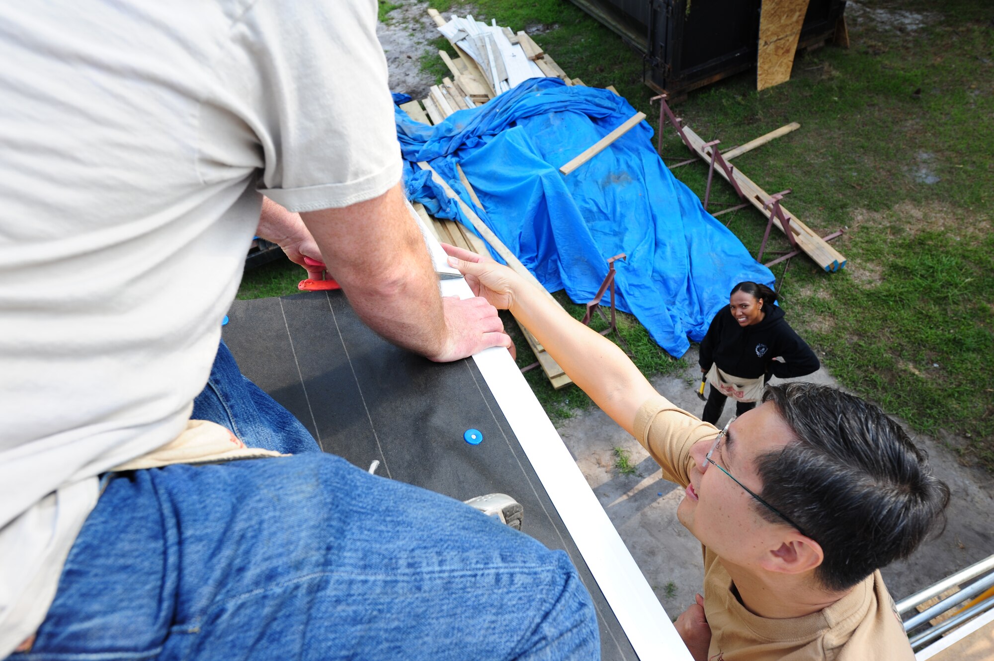 SEYMOUR JOHNSON AIR FORCE BASE, N.C. -- Chaplain (Maj.) Andrew Pak assists Senior Master Sgt. Richard Mitchell in trimming an edging piece on a home being built by Habitat for Humanity with the help of Airmen and dependents here, May 10, 2011. Habitat for Humanity is a non-profit organization that builds houses for people in need within the community. Chaplain Pak, 4th Fighter Wing Chapel, hails from Glendale, Calif., and Sergeant  Mitchell, 4th Force Support Squadron Operations Superintendent, is from Gaithersburg, Md. (U.S. Air Force photo/Senior Airman Rae Perry)(RELEASED)