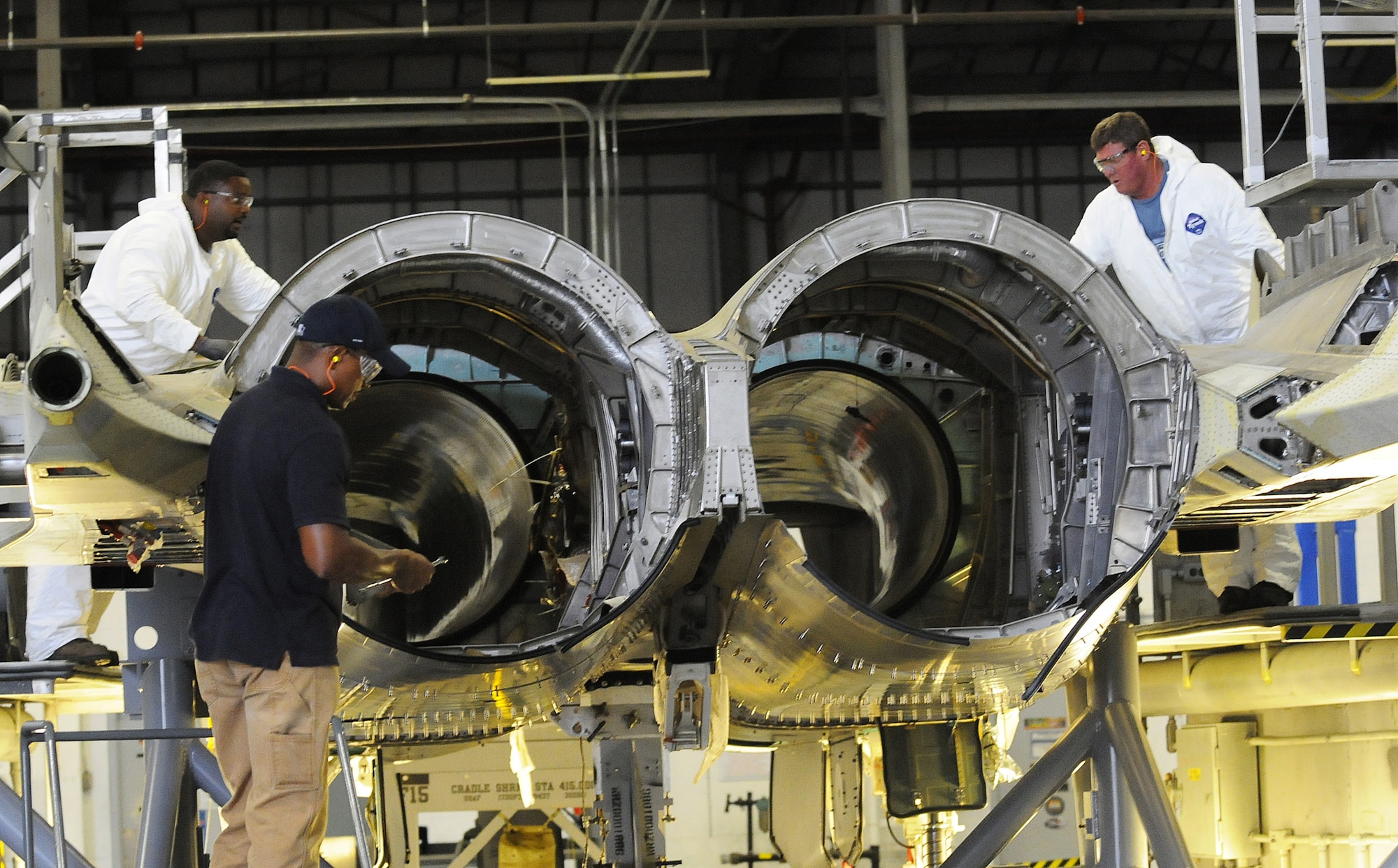 L-R, Derek Seay, Dennis Pickett and Richard Isom work on the replacement aft fuselage after the old old was damaged due to a bird strike. U. S. Air Force photo by Sue Sapp