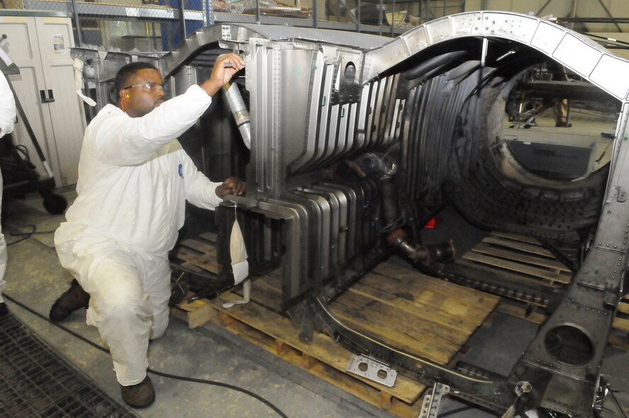 Derek Seay, sheet metal mechanic, uses a ruler to measure damage from a fire caused by a bird strike to the F-15 aft fuselage. U. S. Air Force photo by Sue Sapp