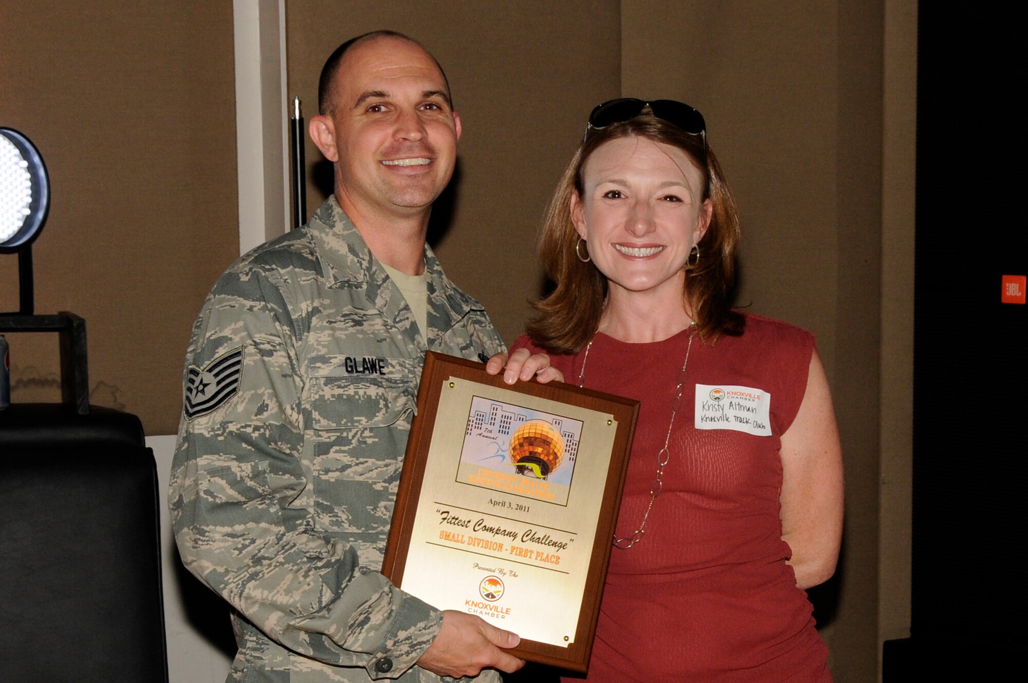 KNOXVILLE, Tenn. - Tech. Sgt. Jeffrey D. Glawe, left, an enlisted professional military education instructor at The I.G. Brown Air National Guard Training and Education Center at McGhee Tyson Air National Guard Base here, accepts a first place award for the Fittest Company Challenge from Kristy Altman, right, of the Knoxville Track Club during a ceremony in Market Square in downtown Knoxville, May 11, 2011.  (U.S. photograph by Master Sgt. Kurt Skoglund/Released)