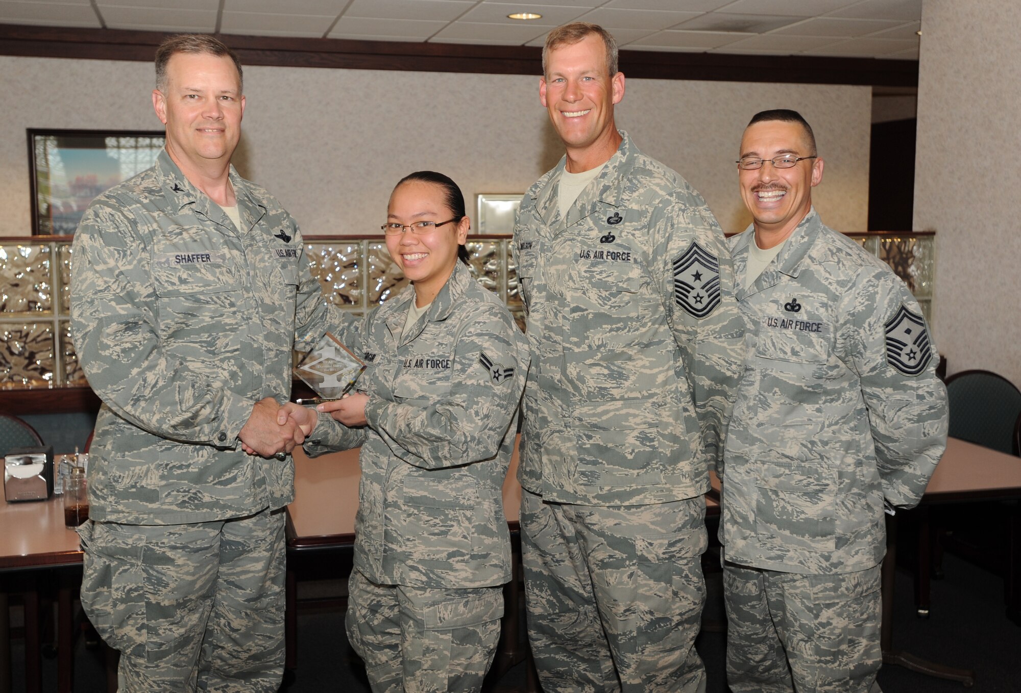 Col. Don Shaffer, 319th Air Base Wing commander, presents Airman 1 st Class Teruko Jo I Fegurgur, 319th Communications Squadron, with a Diamond Sharp Award May 11 at Airey Dining Facility here, accompanied by Command Chief Master Sgt. David Carlson, 319th Air Base Wing, and Senior Master Sgt. Keith Waltz, 319th Communications Squadron first sergeant. The Diamond Sharp Award is given to those Airmen who epitomize service before self and strive for excellence at work and off duty. (U.S. Air Force photo by Staff Sgt. Suellyn Nuckolls)