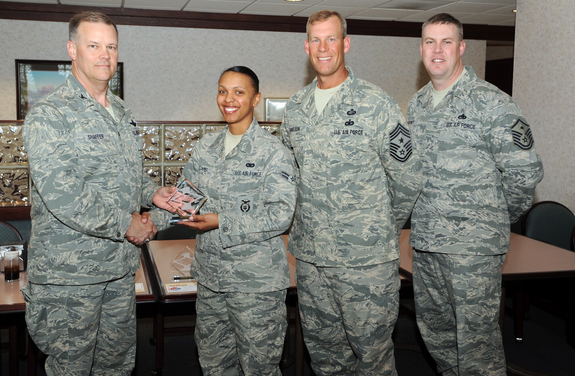 Col. Don Shaffer, 319th Air Base Wing commander, presents Airman 1st Class Christina Williams, 319th Security Forces Squadron, with a Diamond Sharp Award May 11 at Airey Dining Facility here, accompanied by Command Chief Master Sgt. David Carlson, 319th Air Base Wing, and Master Sgt. Michael Bedney, 319th SFS first sergeant. The Diamond Sharp Award is given to those Airmen who epitomize service before self and strive for excellence at work and off duty. (U.S. Air Force photo by Staff Sgt. Suellyn Nuckolls)