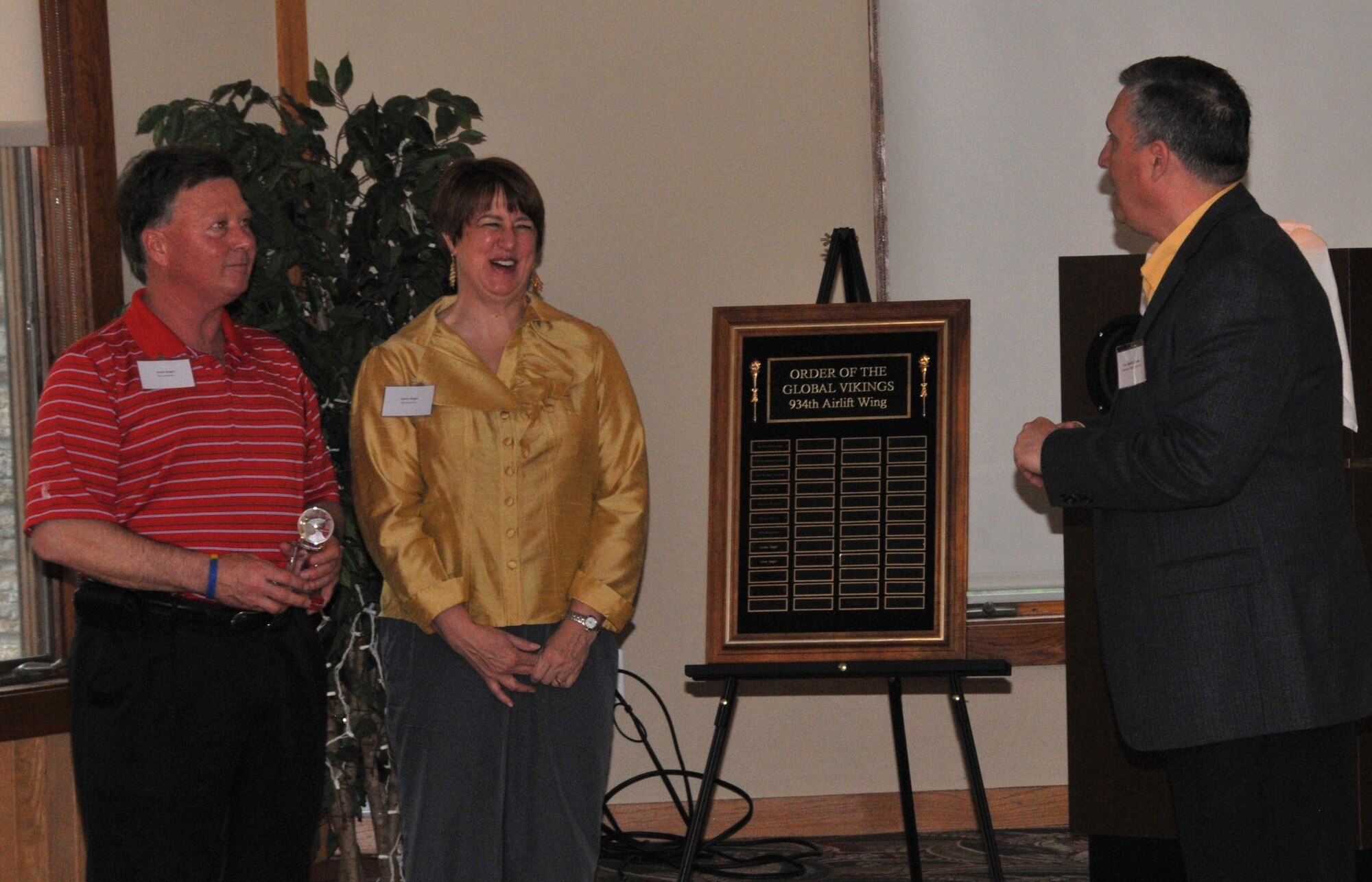 Col. Darrell G. Young, 934th Airlift Wing commander, congratulates Scott and Laura Siegel on their induction into the Order of the Global Vikings at a ceremony May 11. The Siegels are major supporters of the 934th Airlift Wing and other military organizations. (Air Force Photo/Sandy Sweep)