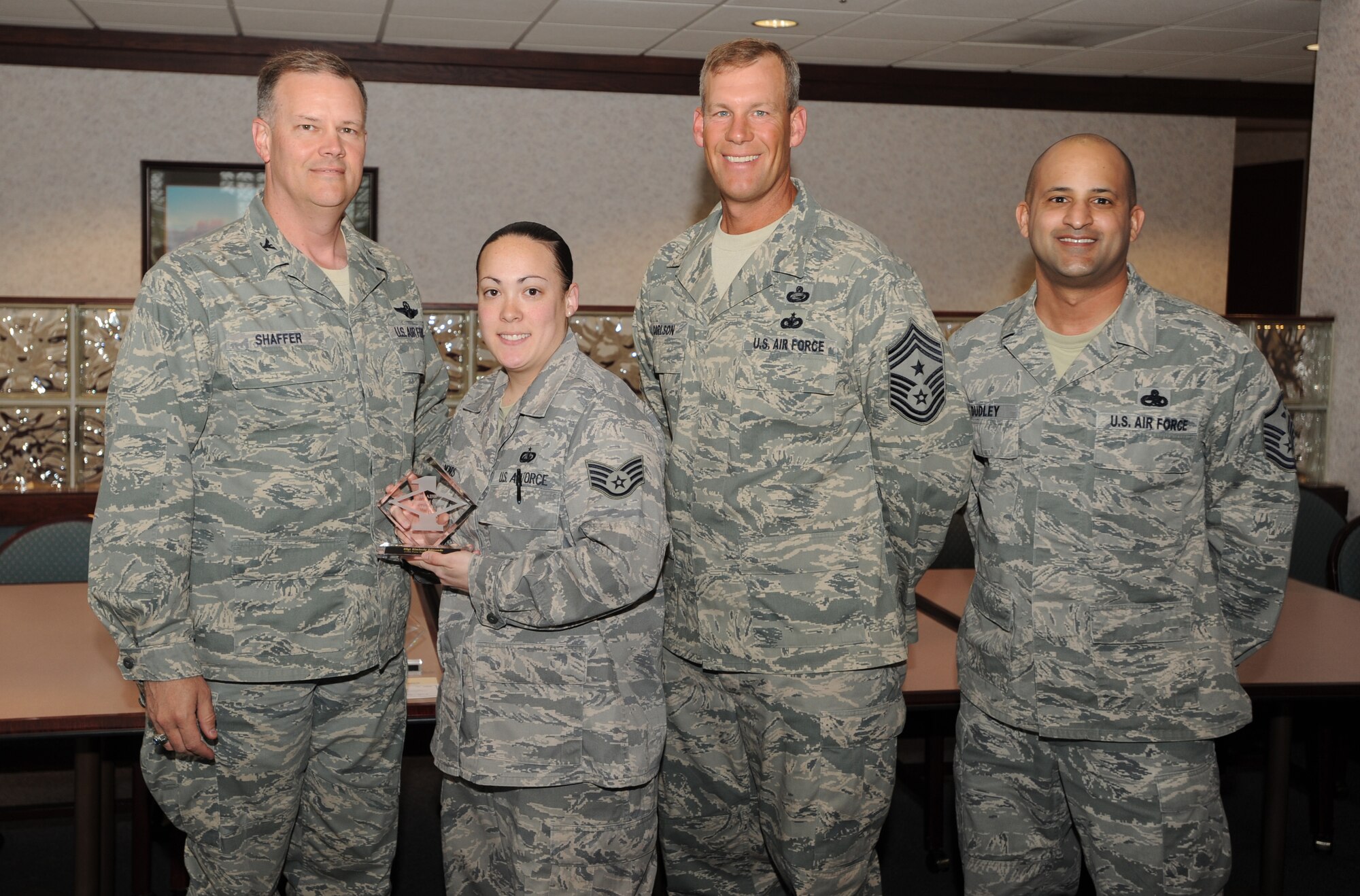 Col. Don Shaffer, 319th Air Base Wing commander, presents Staff Sgt. Kimberly Edmonds, 319th Force Support Squadron, with a Diamond Sharp Award May 11 at Airey Dining Facility here, accompanied by Command Chief Master Sgt. David Carlson, 319th Air Base Wing, and Master Sgt. Luca Dudley, 319th FSS first sergeant. The Diamond Sharp Award is given to those Airmen who epitomize service before self and strive for excellence at work and off duty. (U.S. Air Force photo by Staff Sgt. Suellyn Nuckolls)