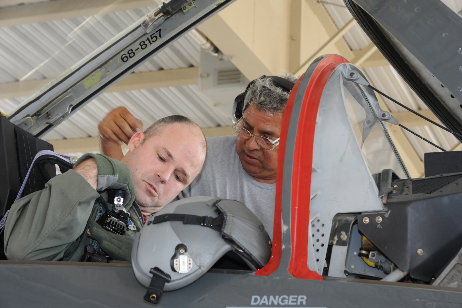 Juan Garcia(right), 12th Flying Training Wing Maintenance Division crew chief, assists Maj. Bryan France, 435th Fighter Training Squadron strap into his  T-38 Talon aircraft prior to a morning training mission at Randolph Air Force Base, Texas May 9, 2011.(U.S. Air Force photo/Rich McFadden)