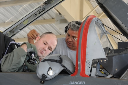 Juan Garcia(right), 12th Flying Training Wing Maintenance Division crew chief, assists Maj. Bryan France, 435th Fighter Training Squadron strap into his  T-38 Talon aircraft prior to a morning training mission at Randolph Air Force Base, Texas May 9, 2011.(U.S. Air Force photo/Rich McFadden)