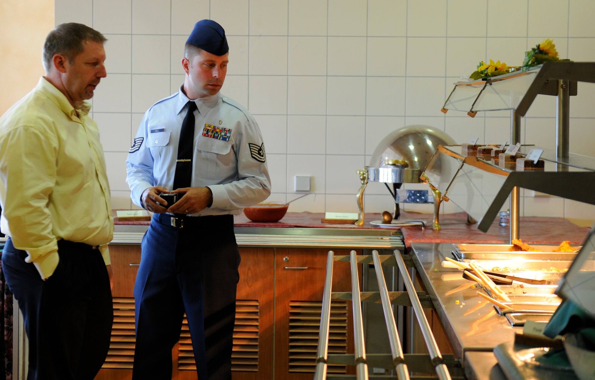 SPANGDAHLEM AIR BASE, Germany – Tech. Sgt. Michael Bell, U.S. Air Force Food Vulnerability Assessment program manager, speaks with Larry Garrett, Club Eifel manager, about vulnerabilities in the food line here May 9. FVAs are performed every three years to ensure all food establishments on base use programs and procedures to prevent and eliminate the contamination of food. (U.S. Air Force photo/Airman 1st Class Brittney Frees)