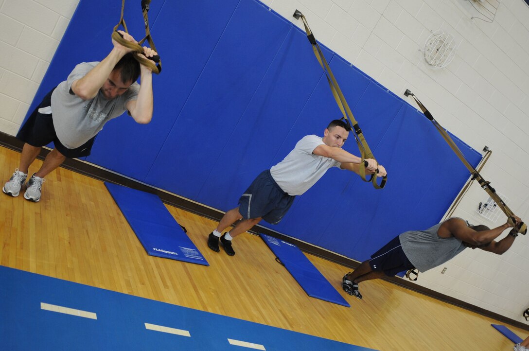 Jim Taccogno, spouse of 1st Lt Sharee Taccogno, 633d Medical Group inpatient clinical nurse, Staff Sgt. Keith Miller, 633d Force Support Squadron fitness specialist, and Maj Freeman Holifield, Air Combat Command bio environmental engineer, participate in a TRX Suspension Training demonstration in the Shellbank Fitness Center at Langley Air Force Base, Va., May 10, 2011. The demonstration was held as part of May Fitness Month which is held annually to promote fitness and healthier lifestyles. (U.S. Air Force photo by Airman 1st Class Kayla Newman/Released)