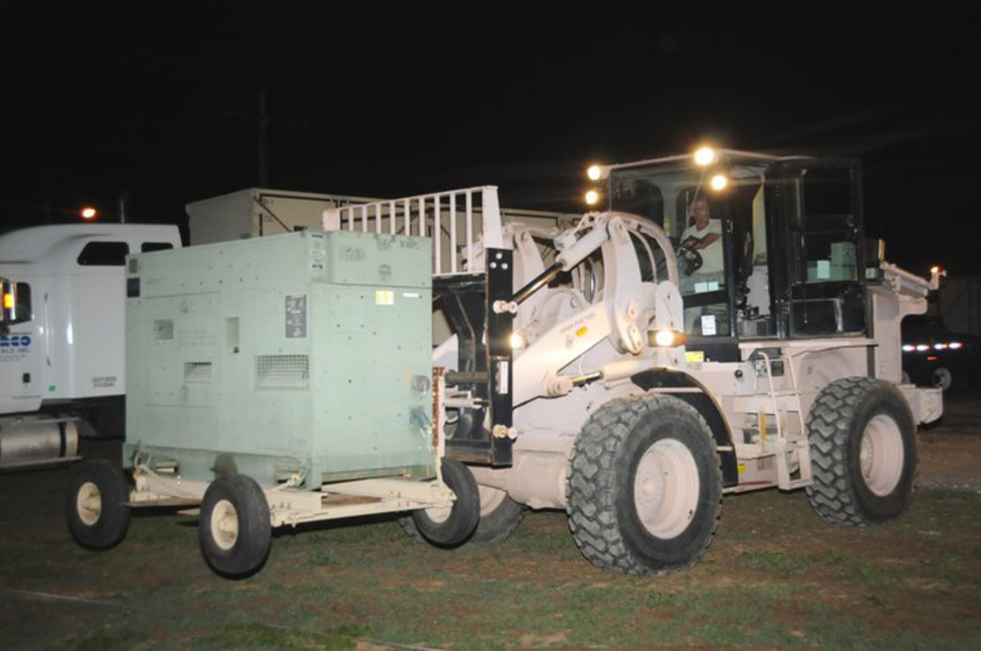 An Airman with the 188th Fighter Wing off loads a generator during the setup of a Disaster Relief Bed-down System (DRBS) in McGehee, Ark., May 11, 2011. Approximately 100 Soldiers and Airmen are in the area to help battle possible flooding from the swollen Mississippi River. (Photo by Staff Sgt. Julian Johnson.)