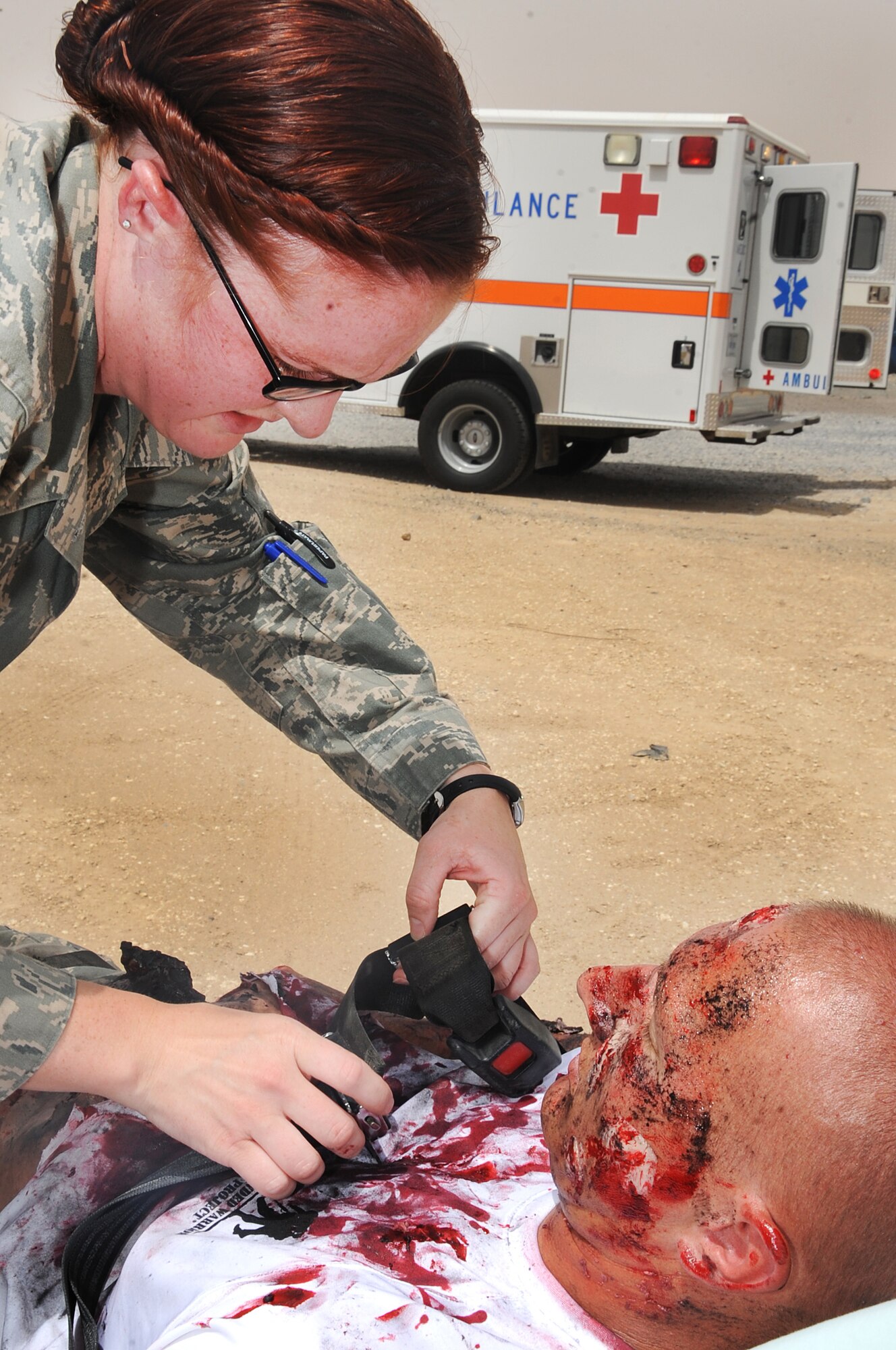 Senior Airman BreAnna Nygren secures Staff Sgt. Andy Hix to a gurney during a simulated rocket blast exercise at the 386th Air Expeditonary Wing. Sergeant Hix was simulating the role of a victim of the blast. Sergeant Hix is the fuels storage supervisor for the 386th Expeditionary Logistics Readiness Squadron and Airman Nygren is an aerospace medicine journeyman with the 386th Expeditionary Medical Group. (U.S. Air Force photo by Senior Airman Cynthia Spalding) 