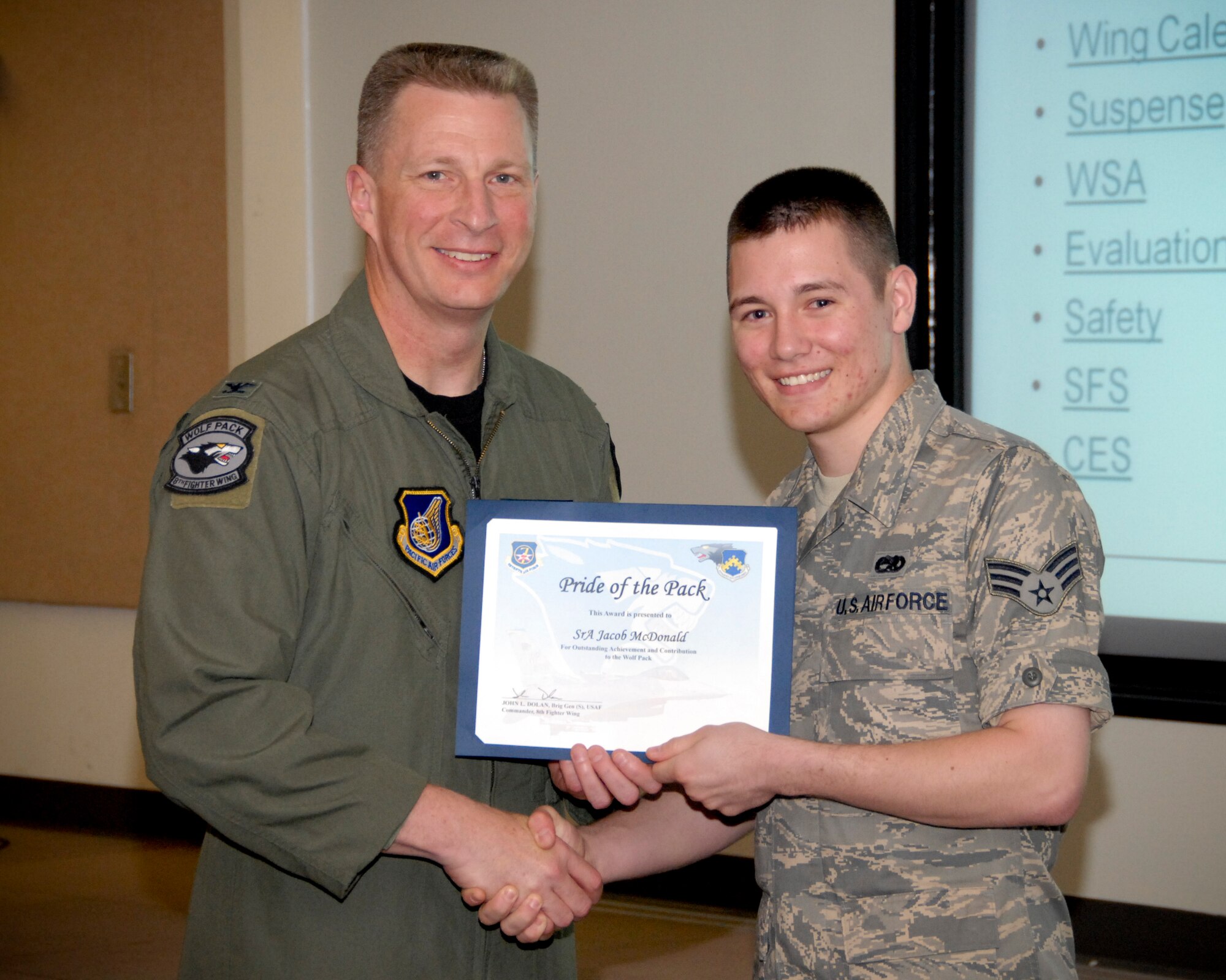KUNSAN AIR BASE, Republic of Korea -- Col. John Dolan, 8th Fighter Wing commander, presents Senior Airman Jacob B. McDonald, 8th Maintenance Squadron, with a Pride of the Pack award here May 12. (U.S. Air Force photo/Capt. Sheryll Klinkel)