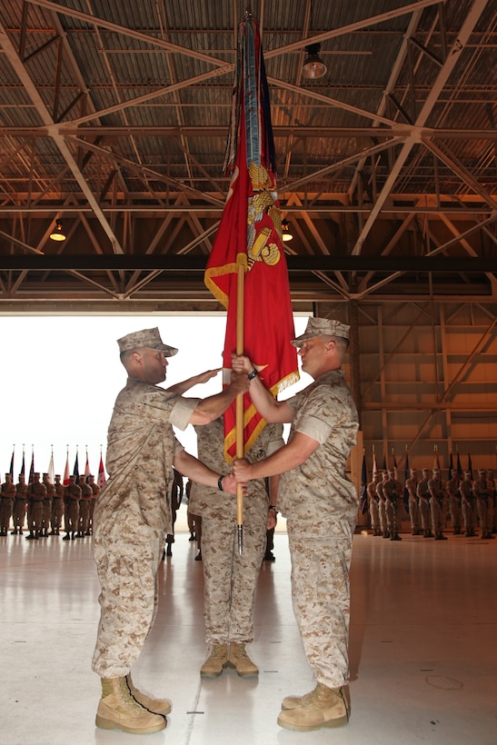 Lt. Col. Joshua L. Luck, right, passes the unit colors to Lt. Col. Michael J. Perez during the Marine Attack Squadron 542 change of command in the squadron’s hangar May 13. The passing of the colors symbolizes the passing of responsibility from one commander to the next.
