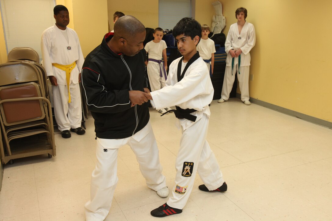 Master Andre L. Evans corrects Mizuki Cruz on his stance and form during tae kwon do practice at the Havelock Recreation Center May 13. The students can spend as many as 30 hours a week in Evan’s classes. Practices are held Monday through Saturday at the Havelock Recreation Center, Cherry Tree House and the Teen Center.