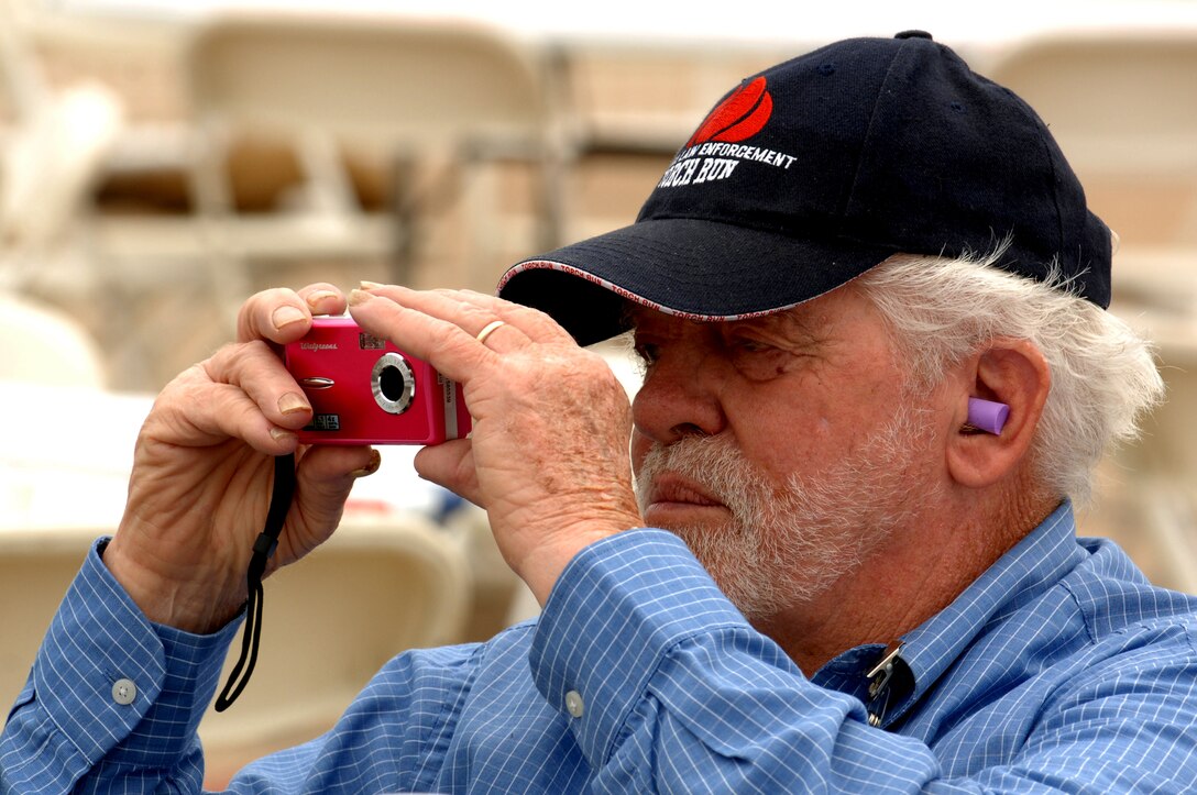 Ronald Riggins, a retired U.S. Army Soldier from Newport News, Va., photographs the U.S. Army Golden Knights Parachute Team during a performance at the AirPower over Hampton Roads open house at Langley Air Force Base, Va., May 13, 2011. The Golden Knights have entertained audiences at air shows, competitions and high profile tandems for 50 years. (U.S. Air Force photo by Staff Sgt. Jeff Nevison)(RELEASED)