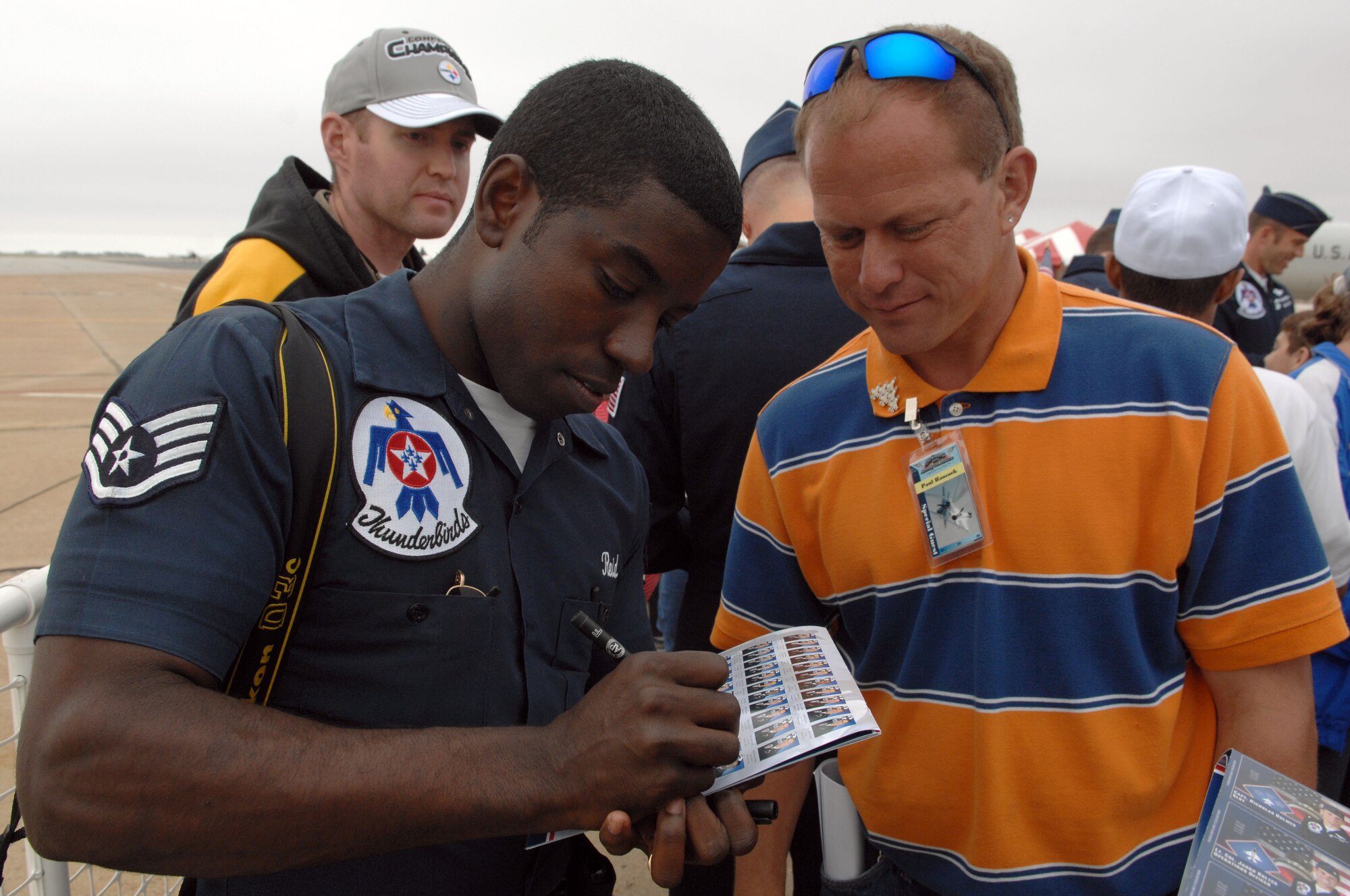 Staff Sgt. Larry Reid, U.S. Air Force Air Demonstration Squadron Thunderbirds team photographer, signs an autograph for Paul Hancock, Hampton Roads Peninsula Special Olympics member, during the AirPower over Hampton Roads open house at Langley Air Force Base, Va., May 13, 2011. The open house gives military and civilian personnel the opportunity to get up-close-and-personal with various aircraft used by the military that they would not otherwise have the chance to experience. (U.S. Air Force photo by Staff Sgt. Jeff Nevison)(RELEASED)