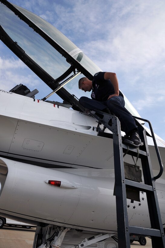 Staff Sgt Brian Emerson, Air Force Thunderbirds Premier Demonstration Team crew chief, performs a final check on an F-16 Fighting Falcon before departure at Langley Air Force Base, Va., May 12, 2011. The Thunderbirds selected Mr. Daniels as the AirPower over Hampton Roads Hometown Hero, for which they rewarded him with an orientation flight in an F-16 Fighting Falcon. (U.S. Air Force photo by Airman 1st Class Camilla Griffin)(RELEASED)
