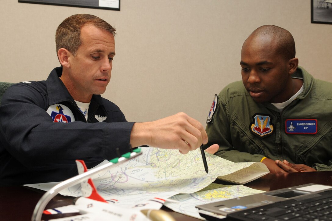 Lt. Col. Jason Koltes, Air Force Thunderbirds Premier Demonstration Team operations officer, maps out the route with Mr. Travis Daniels, emergency medical technician, at Langley Air Force Base, Va., May 12, 2011. The Thunderbirds selected Mr. Daniels as the AirPower over Hampton Roads Hometown Hero, for which they rewarded him with an orientation flight in an F-16 Fighting Falcon. (U.S. Air Force photo by Airman 1st Class Racheal Watson)(RELEASED)
