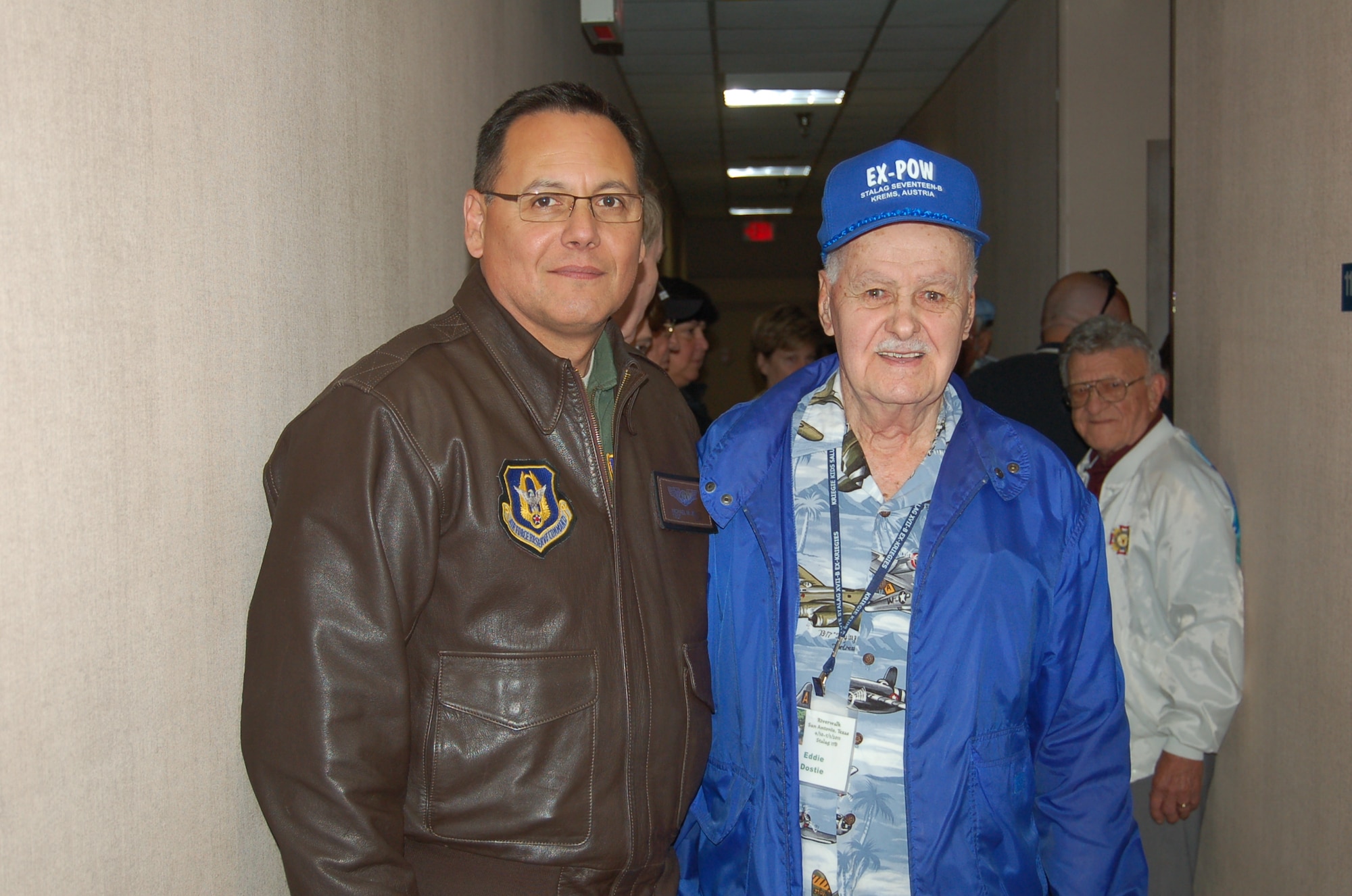 (At right) Prisoner of War, Edward Dostie, a former flight engineer on a B-17 Flying Fortress during World War II, poses with Tech. Sgt Michael Jones, also a flight engineer from the 68th Airlift Squadron, Lackland Air Force Base, Texas. POW Vincent Pale in the background looks on. Both flight engineers swapped stories and experiences during the Hogan’s Heroes annual reunion held May 2, 2011 at the 433rd Airlift Wing, Lackland Air Force Base, Texas. (U.S. Air Force photo/Senior Master Sgt. Minnie Jones)