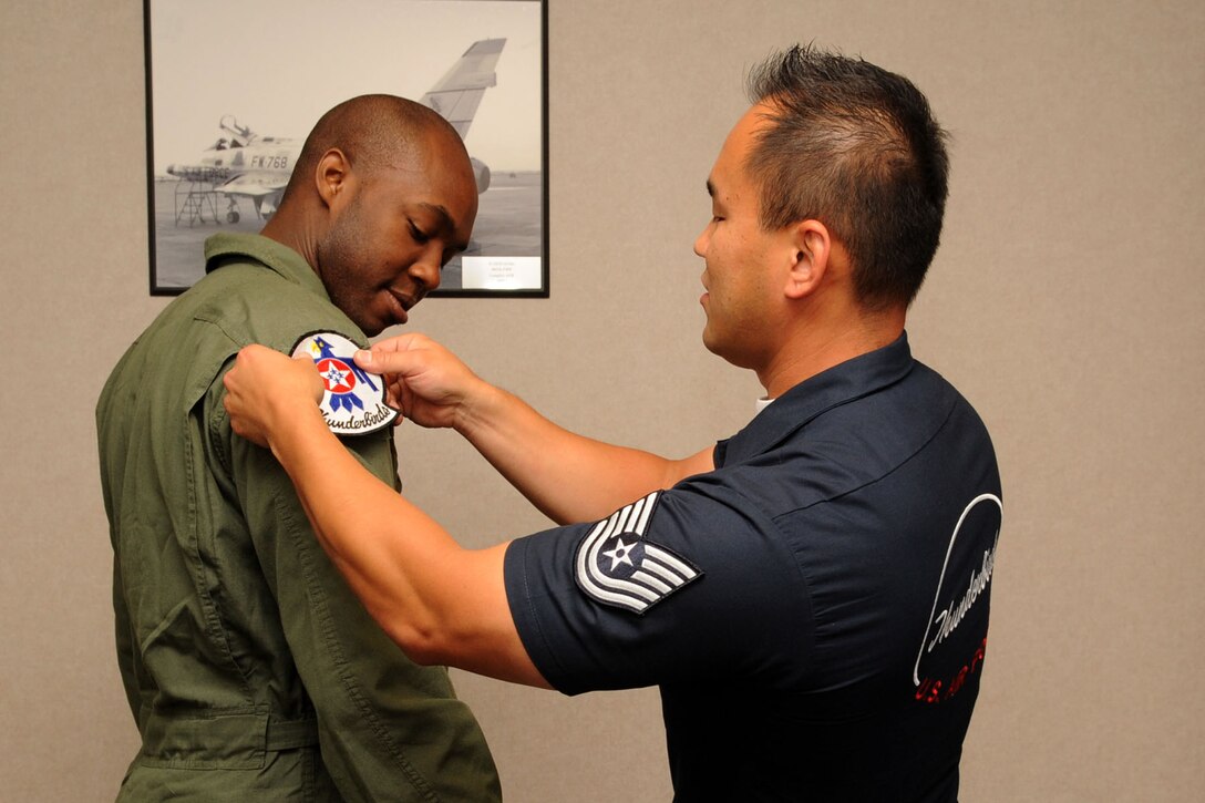 Tech. Sgt. Sang Lee, Air Force Thunderbirds Premier Demonstration Team aircrew flight equipment specialist, places the Thunderbird patch on Mr. Travis Daniels’, emergency medical technician, flight suit at Langley Air Force Base, Va., May 12, 2011. The Thunderbirds selected Mr. Daniels as the AirPower over Hampton Roads Hometown Hero, for which they rewarded him with an orientation flight in an F-16 Fighting Falcon. (U.S. Air Force photo by Airman 1st Class Racheal Watson)(RELEASED)