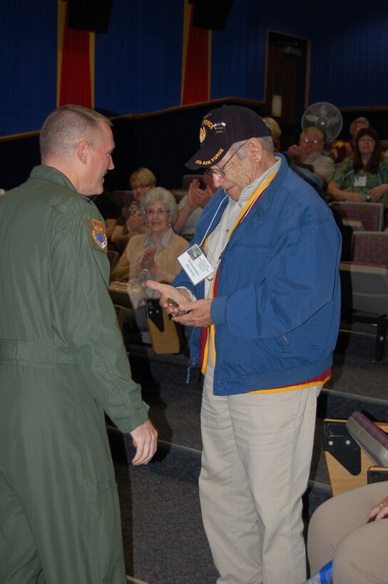 Prisoner of war, Joe Ortiz, a former ball turret gunner on a B-24 Liberator and vice commander of a POW group during World War II, receives a coin from Col. Kenneth D. Lewis, Jr., 433rd Airlift Wing commander, Lackland Air Force Base, Texas, during the tour of the wing, May 2. Mr. Ortiz was assigned to the 392nd Bomb Group, 576th Squadron based in Wendling, England. (U.S. Air Force photo/Senior Master Sgt. Minnie Jones)