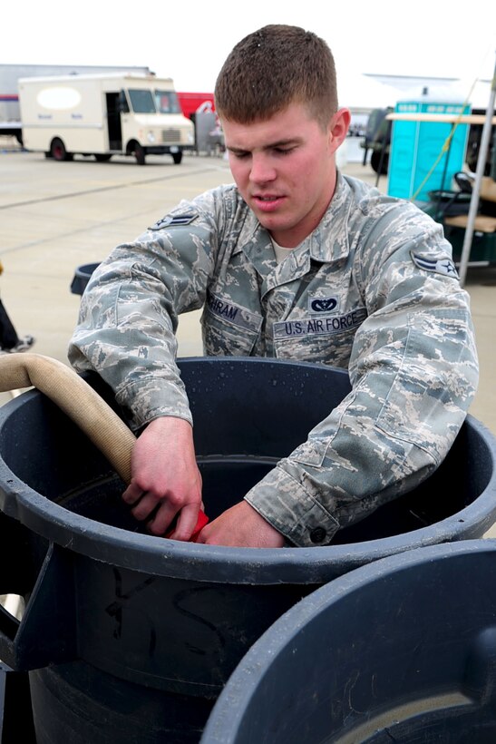 Airman 1st Class Benjamin Schram, 633d Civil Engineer Squadron "dirt boy", fills trash cans with water to support the tents during the AirPower over Hampton Roads open house at Langley Air Force Base, Va., May 13, 2011. Military personnel from around the base worked from the beginning of the air show until the end, making the event a wonderful experience for all to enjoy. (U.S. Air Force photo by Staff Sgt. Ashley Hawkins)(RELEASED)