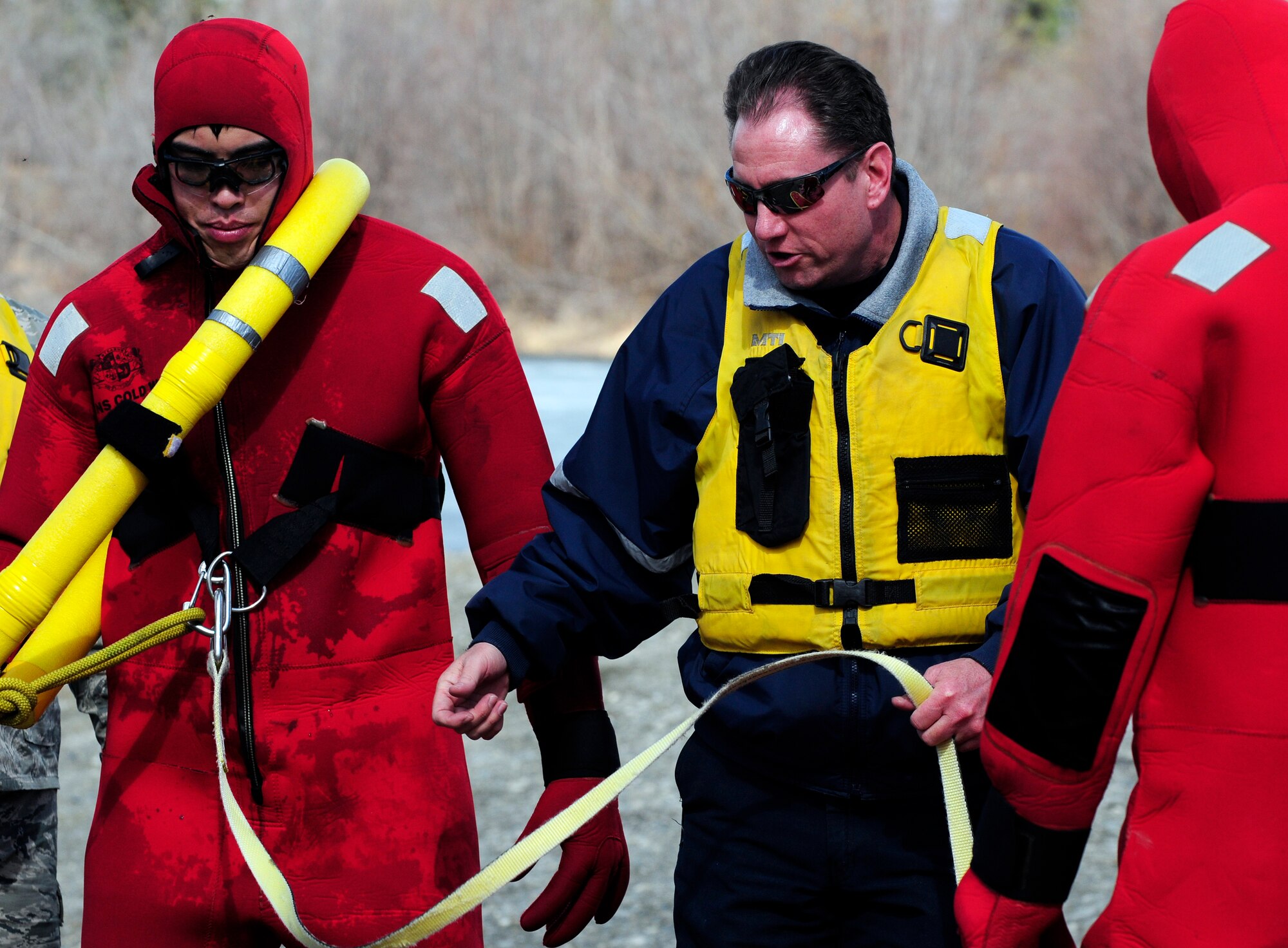 Mr. Jeff Akin demonstrates with Senior Airman Bao Hoang how to properly lasso a victim during ice water rescue training May 6, 2011, Eielson Air Force Base, Alaska.  Emergency rescue Airmen train to stay prepared in the event of an emergency since Alaska lakes are frozen nine to 10 months of the year. Airmen Hoang is a fire fighter and Mr. Akin is a training manager, both are assigned to the 354th Civil Engineer Squadron Fire Protection Flight. (U.S. Air Force photo/Airman 1st Class Laura Goodgame)