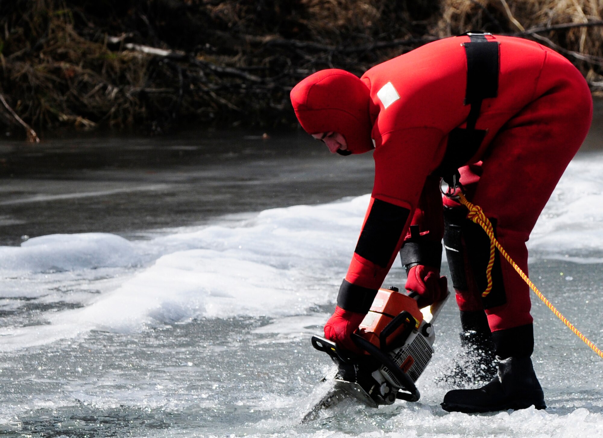 Staff Sgt. Eric Brownsell uses a chainsaw to make a hole in a frozen lake during ice water rescue training May 6, 2011, Eielson Air Force Base, Alaska. Emergency rescue Airmen train to stay prepared in the event of an emergency since Alaska lakes are frozen nine to 10 months of the year. Sergeant Brownsell is assigned to the 354th Civil Engineer Squadron Fire Protection Flight. (U.S. Air Force photo/Airman 1st Class Laura Goodgame)